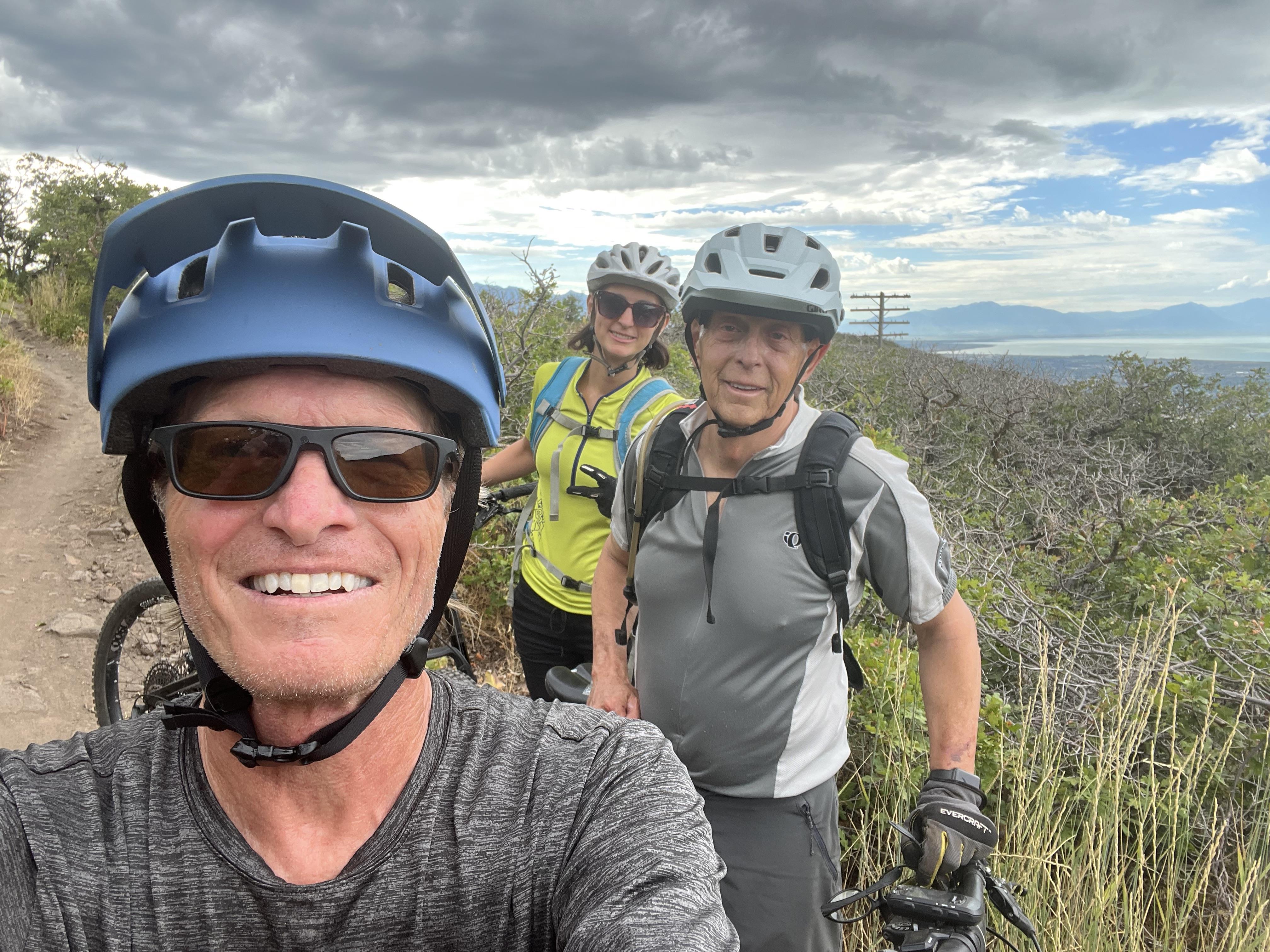 A group of people wearing helmets and standing on a hill