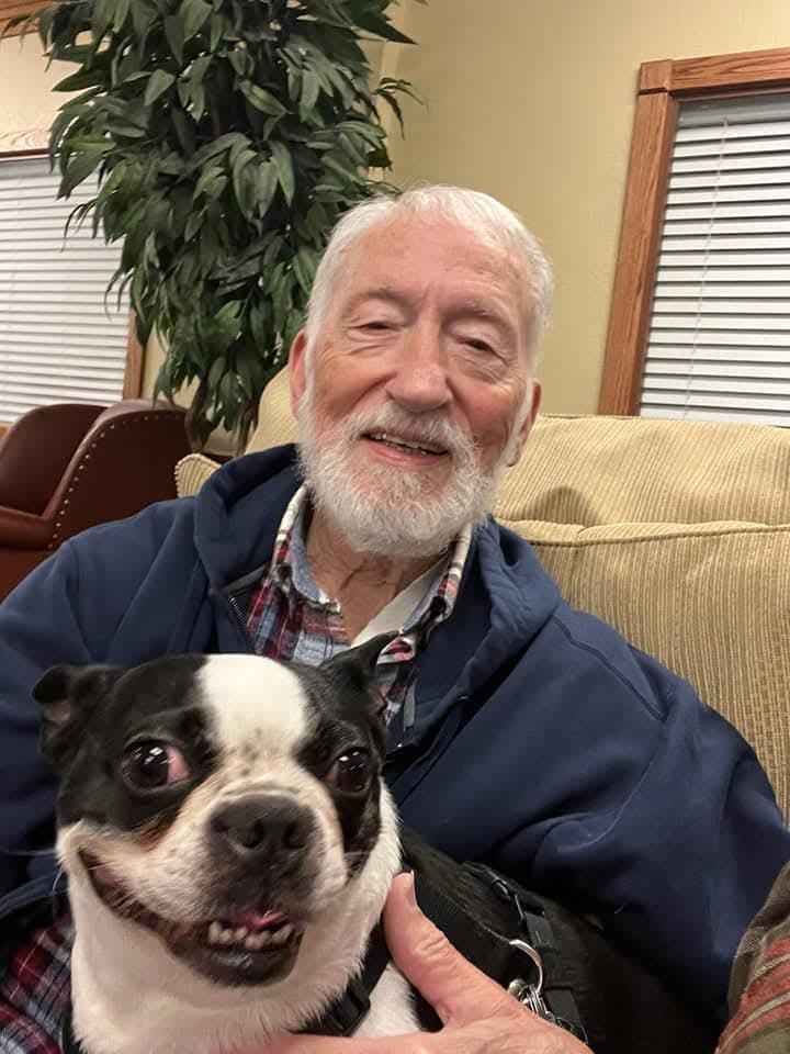A man sitting on a couch with a dog