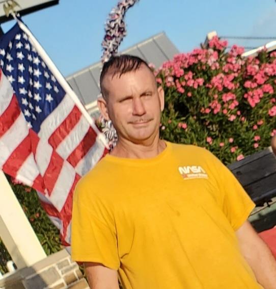 A man standing in front of a flag