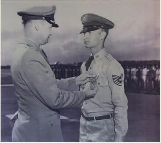 A man in military uniform giving a medal to another man