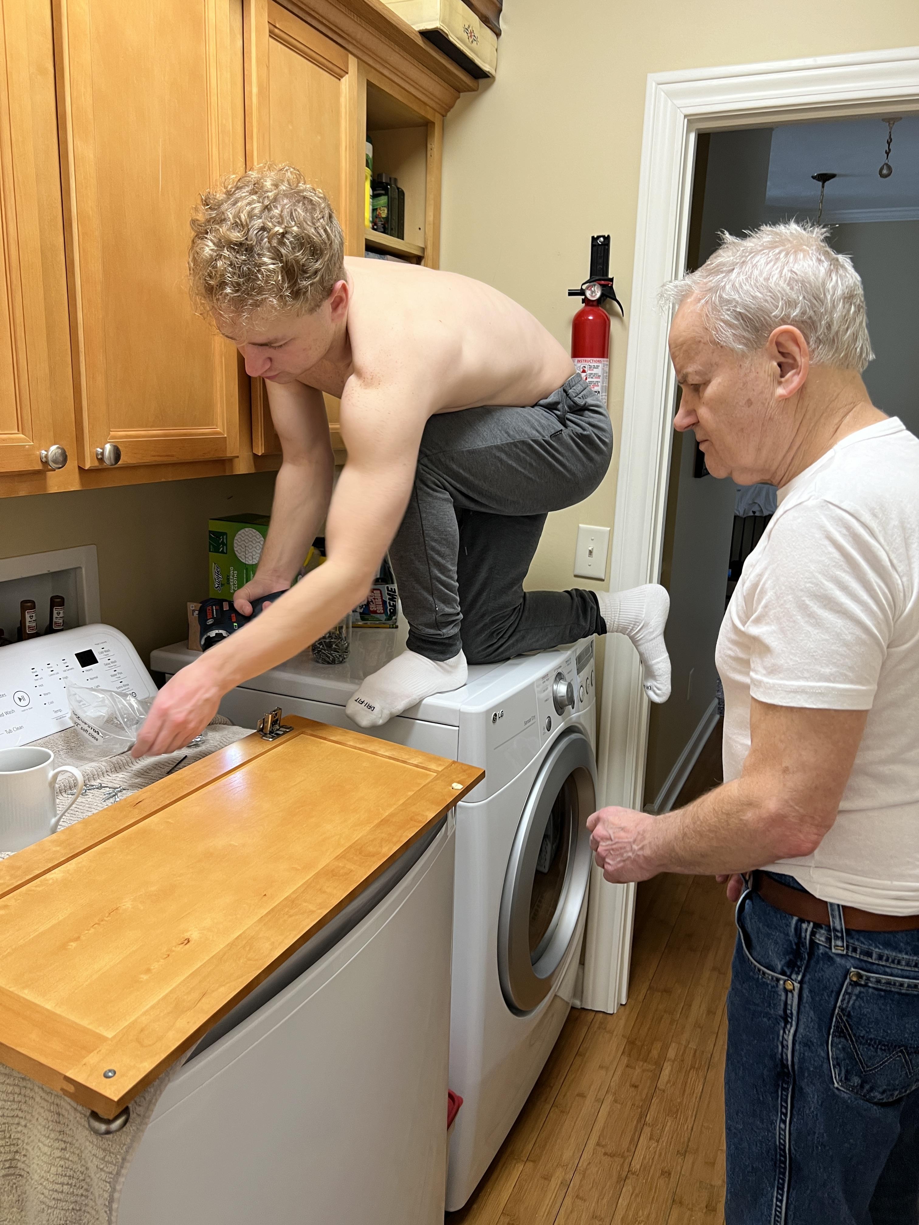 A man standing on top of a washing machine