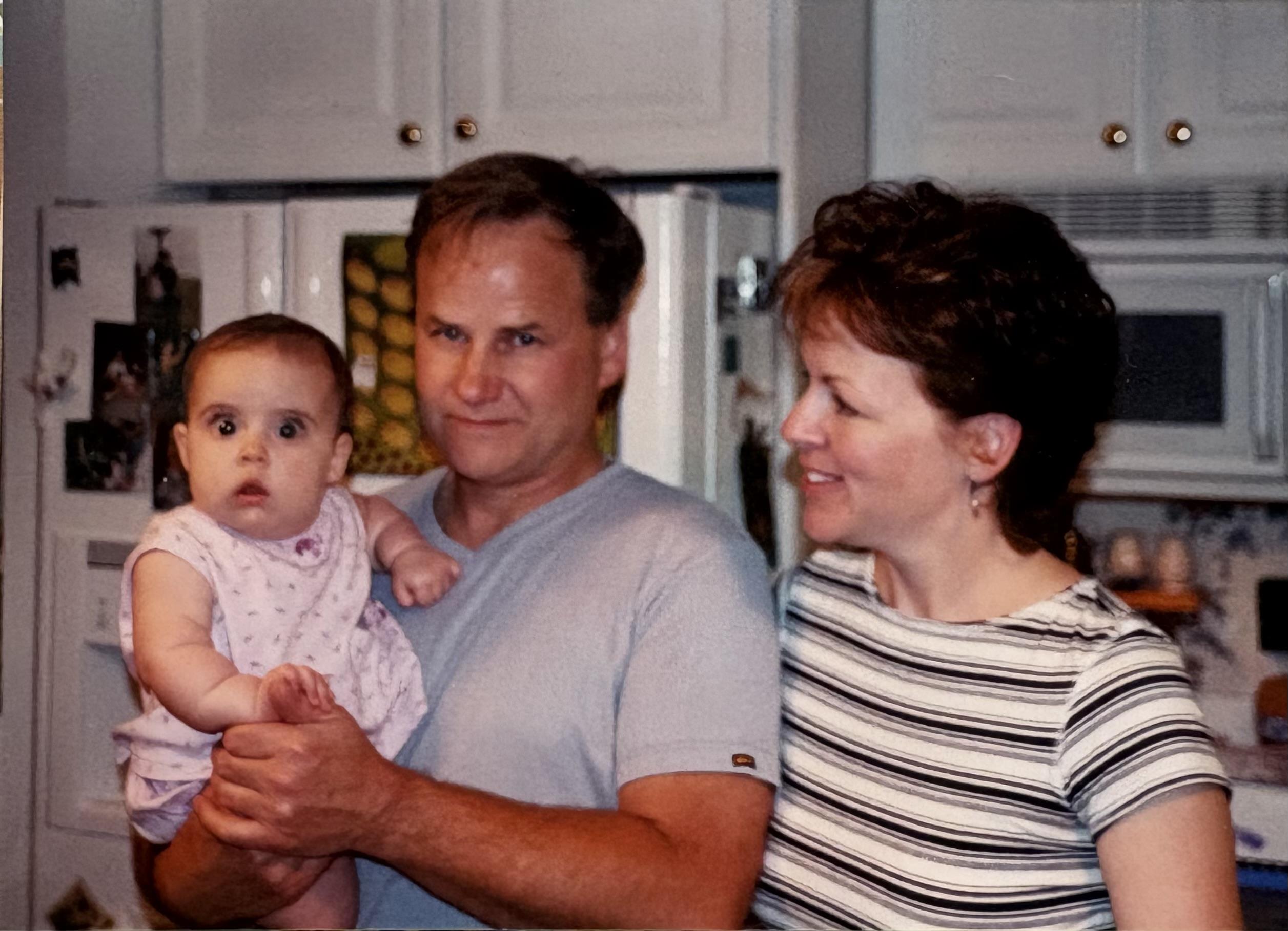 A man and woman holding a baby