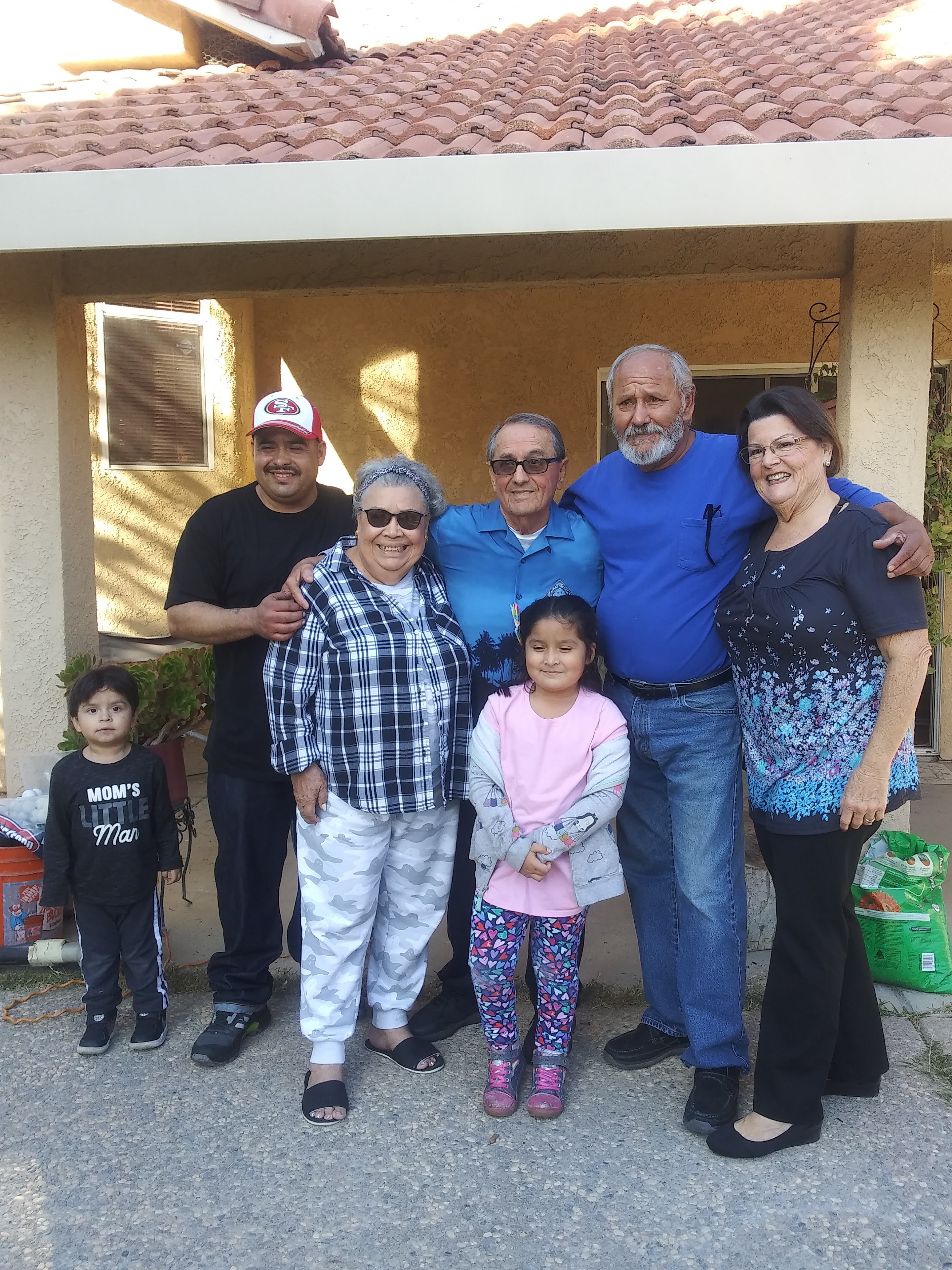 A group of people standing in front of a house