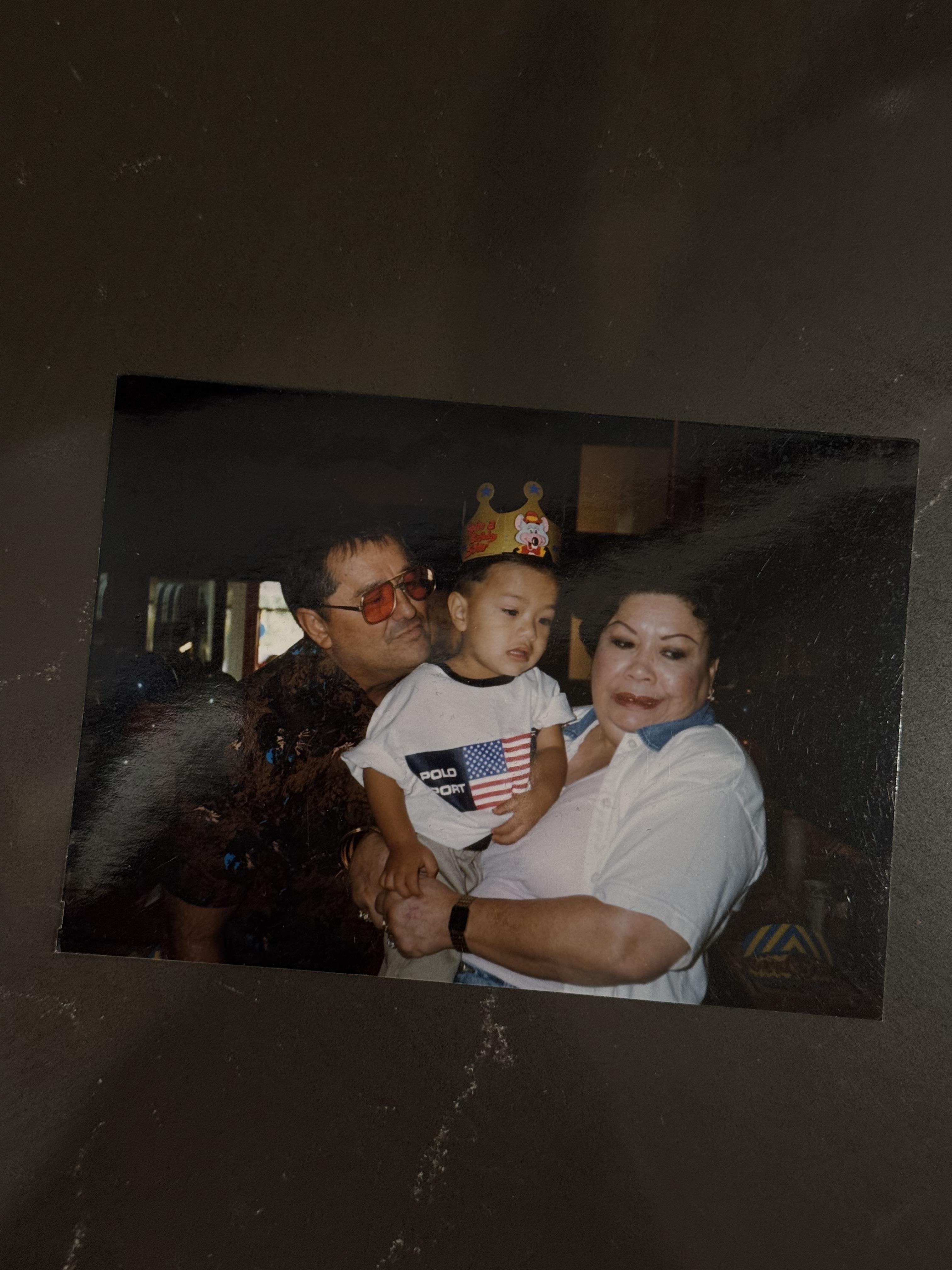 A family photo of a man and woman holding a child