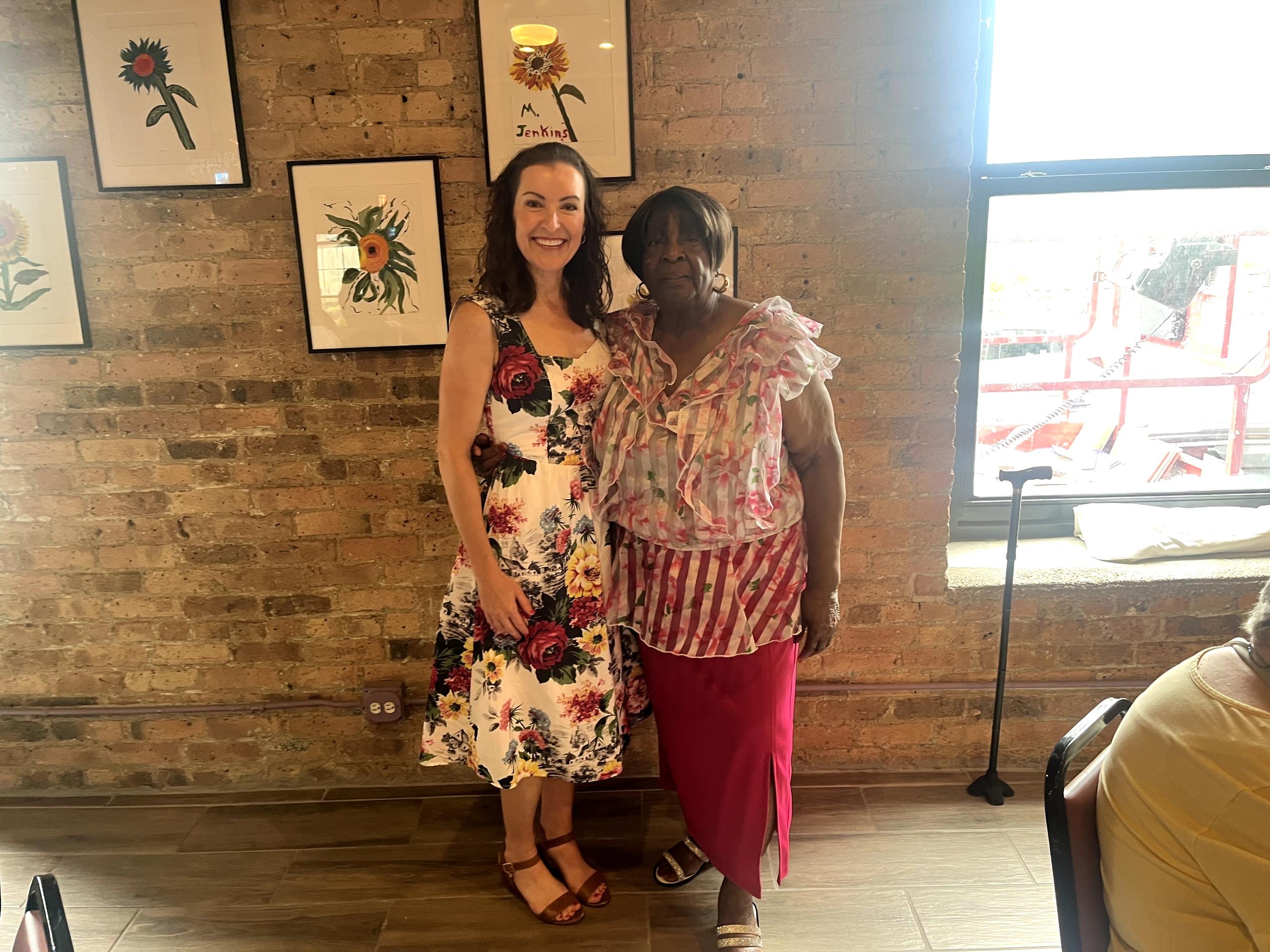 Two women standing in front of a brick wall