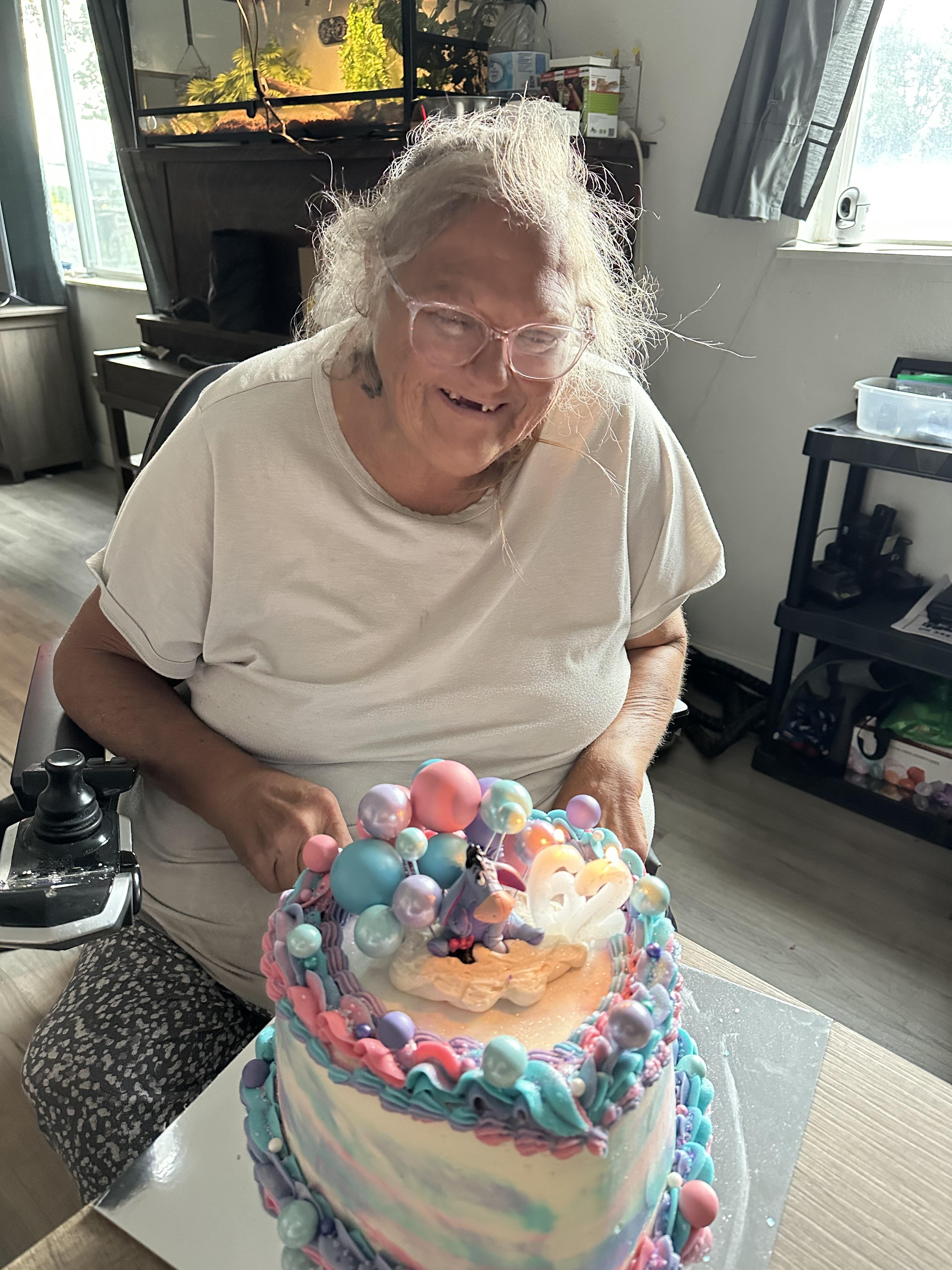 A woman sitting in front of a cake