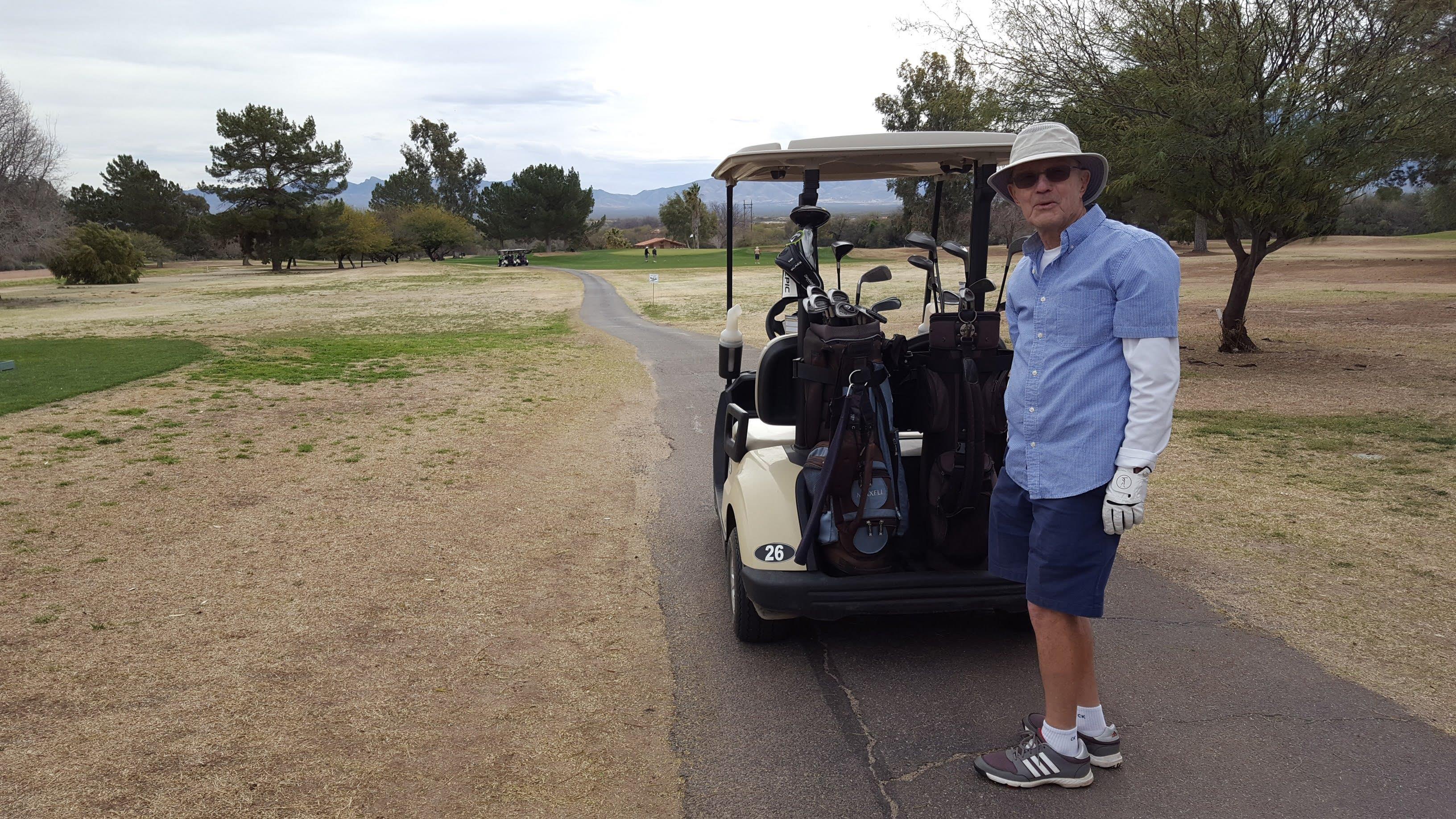 A man standing next to a golf cart