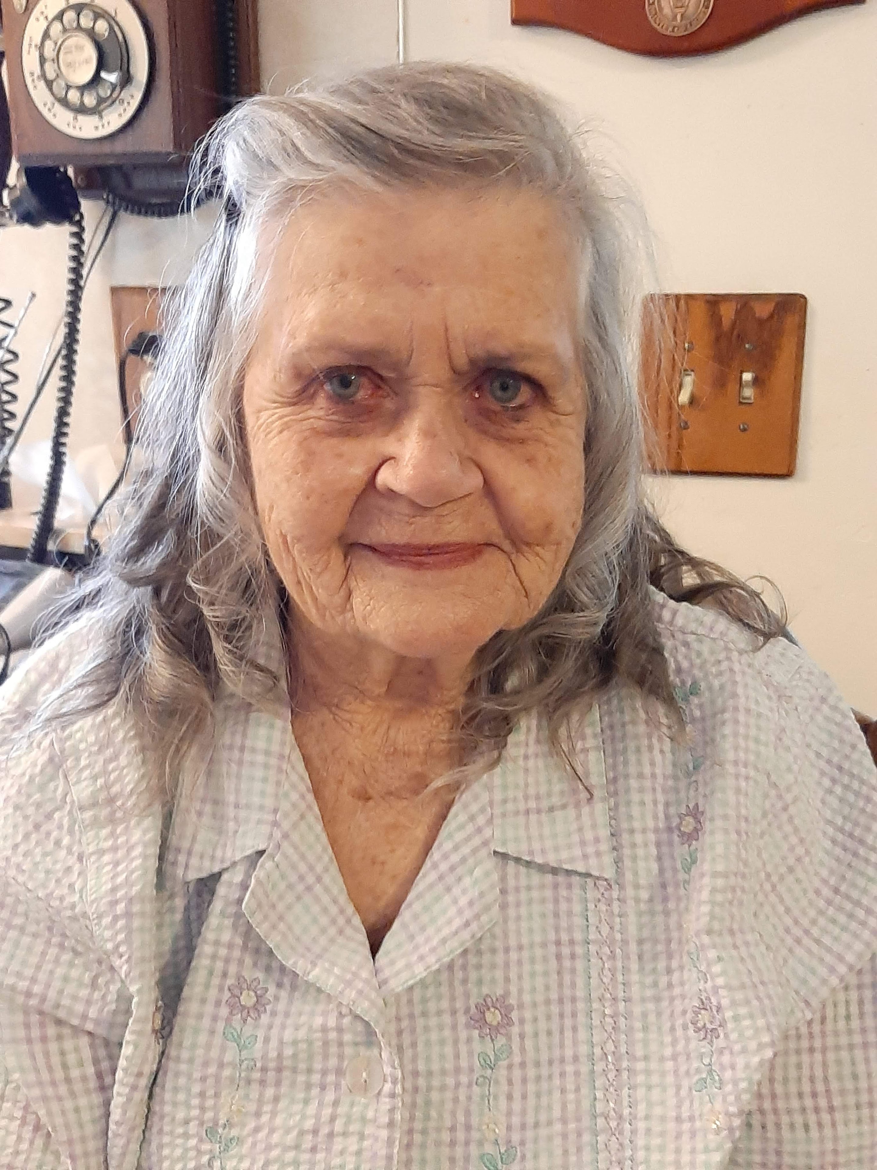 A woman with grey hair and a white shirt