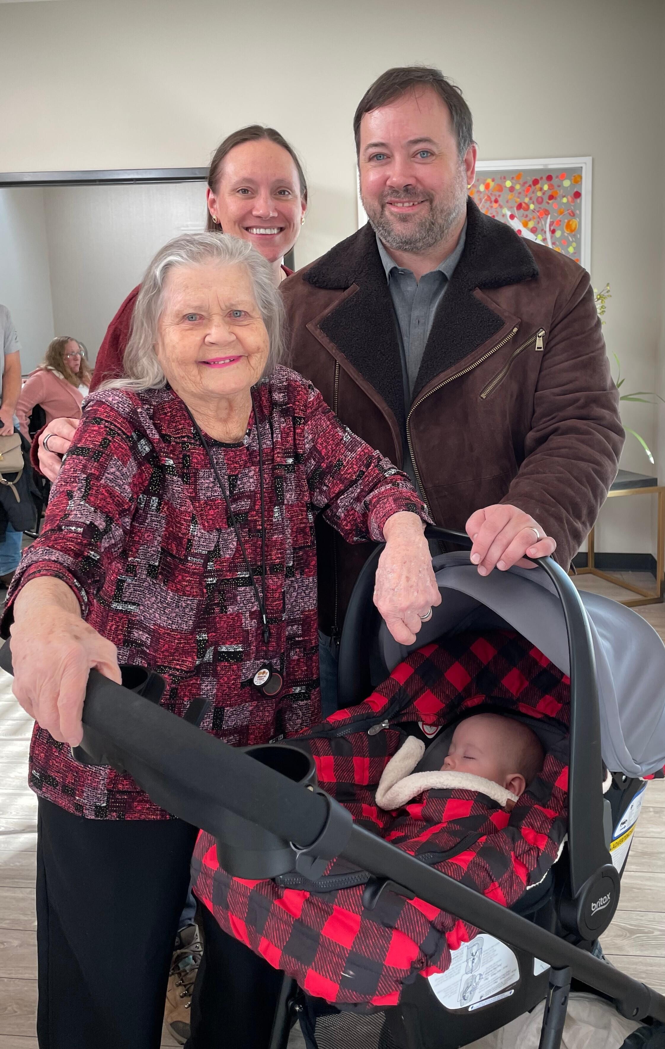 A group of people standing next to a baby