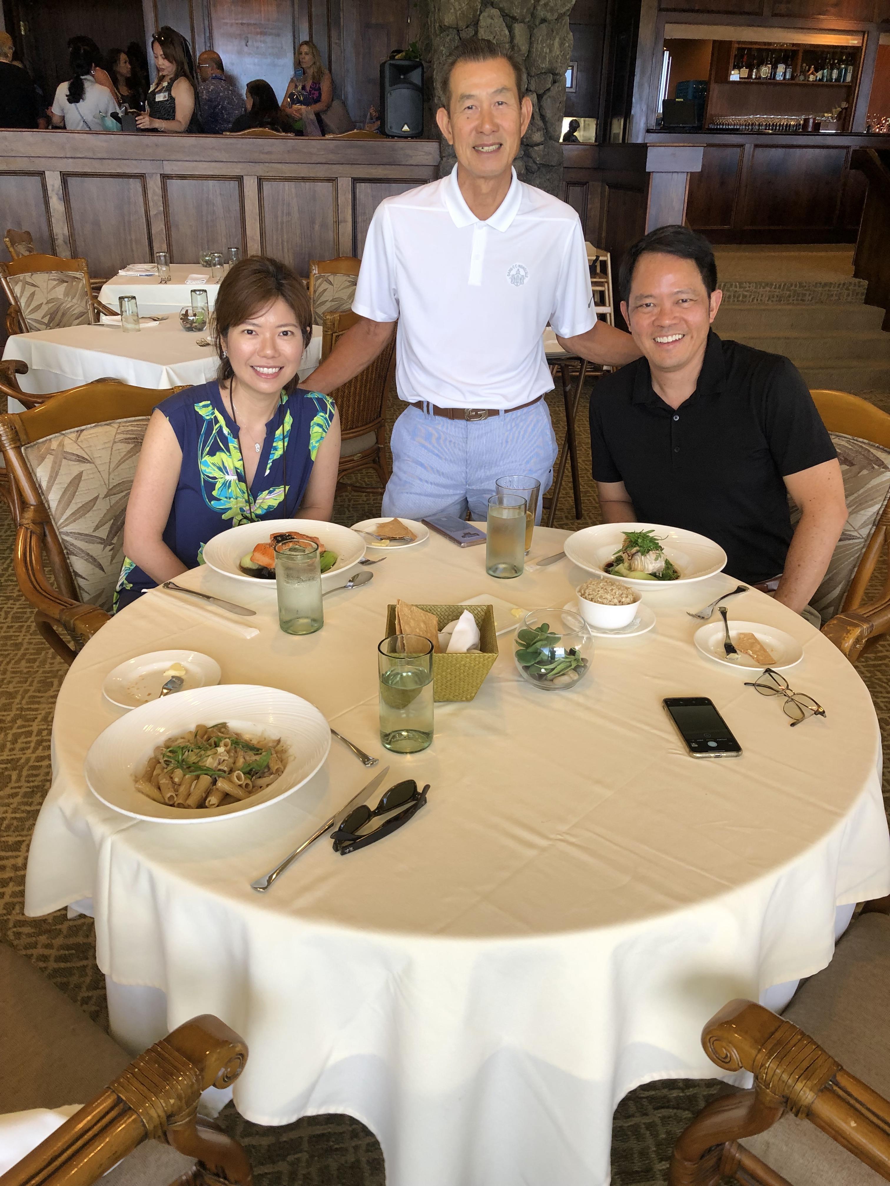 A group of people sitting at a table with food