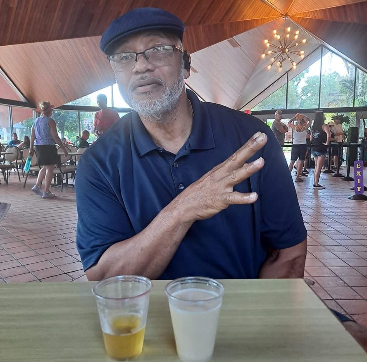 A man sitting at a table with two cups of beer