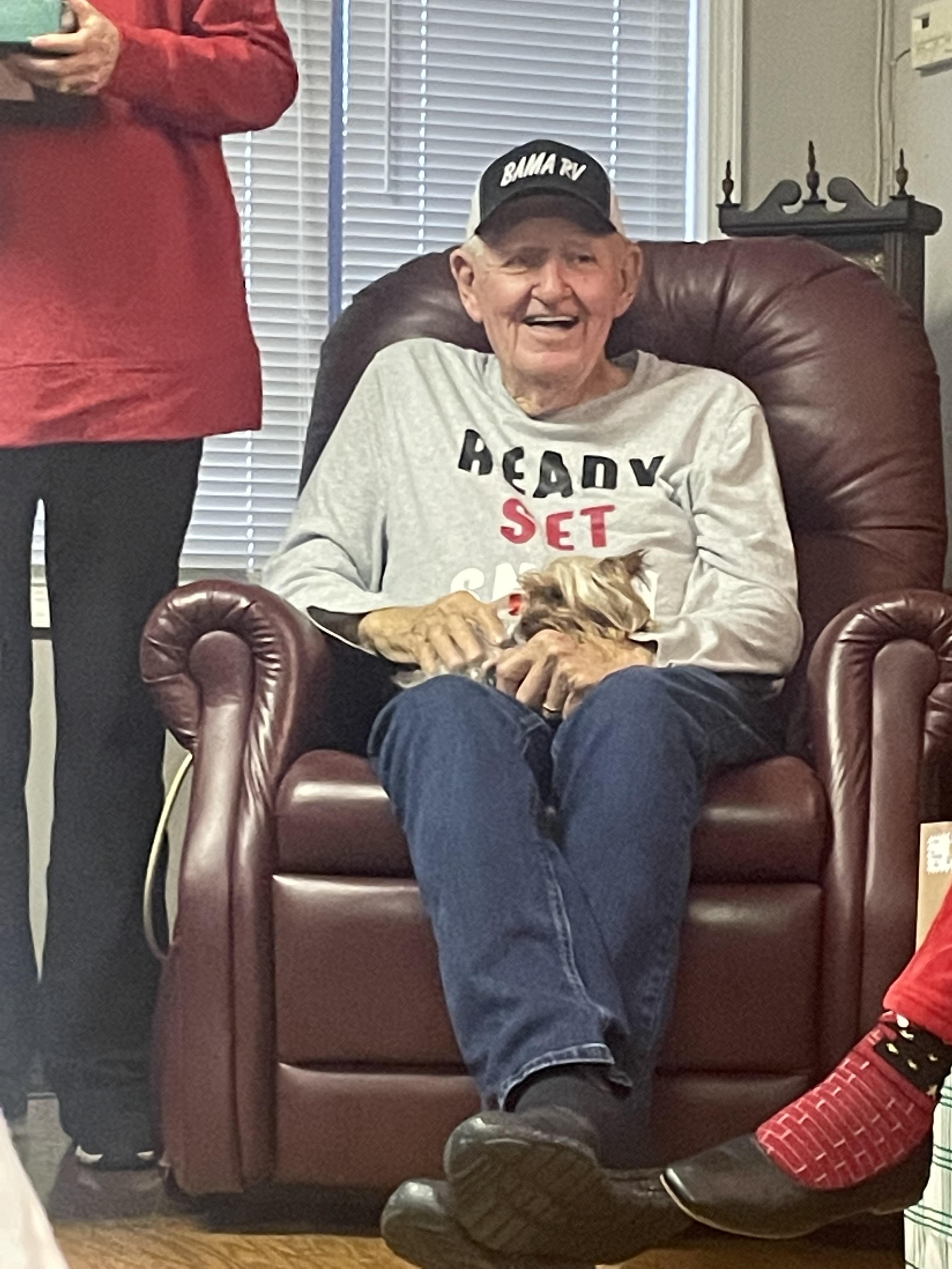 A man sitting in a chair with a dog