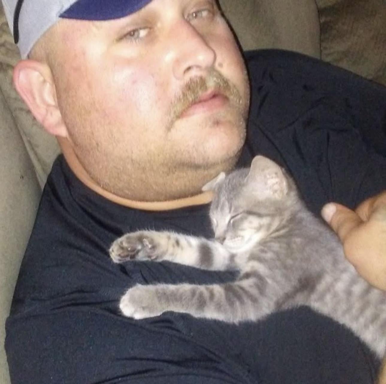 A man lying on a couch with a cat