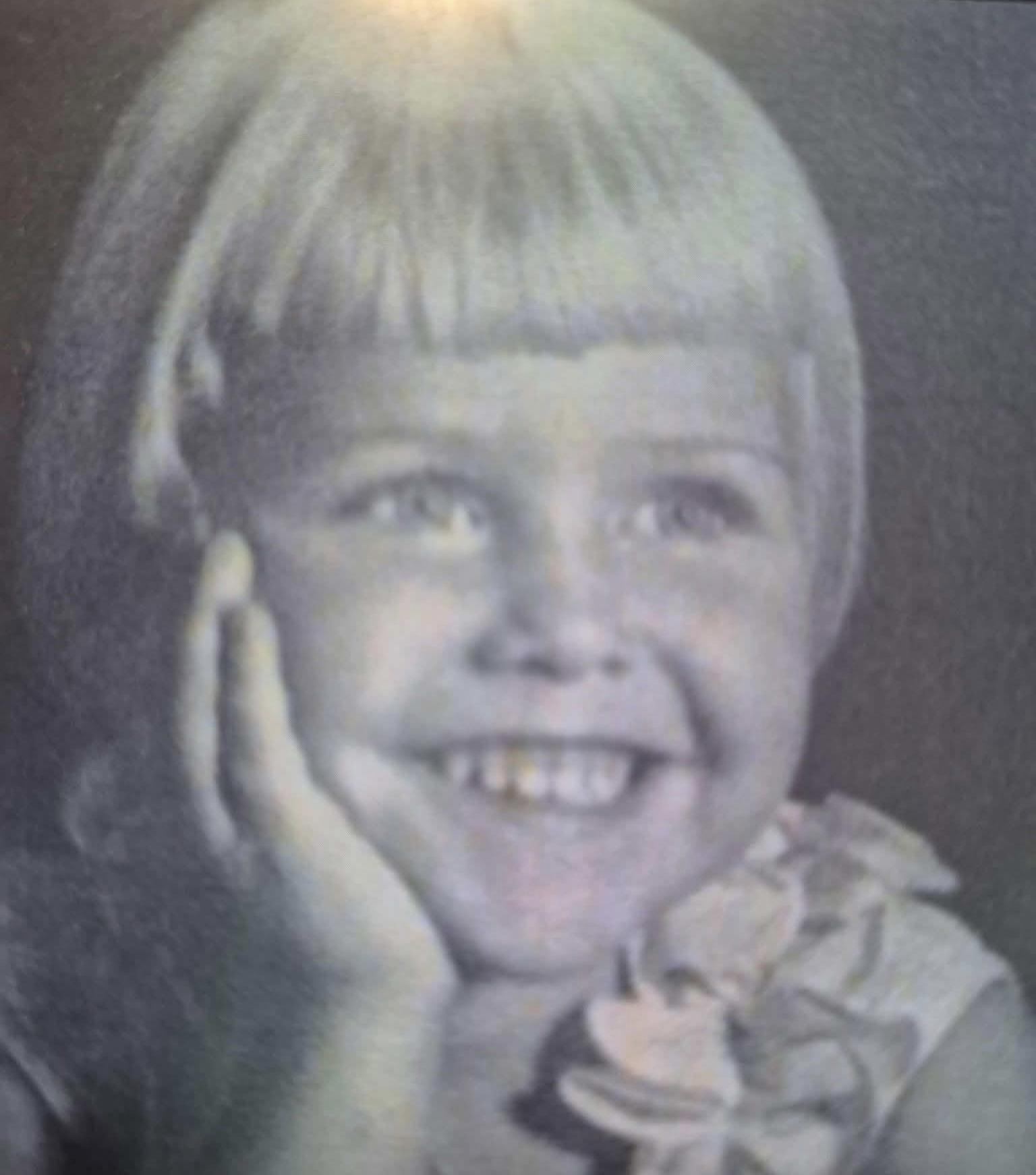 A child with her hand on her face