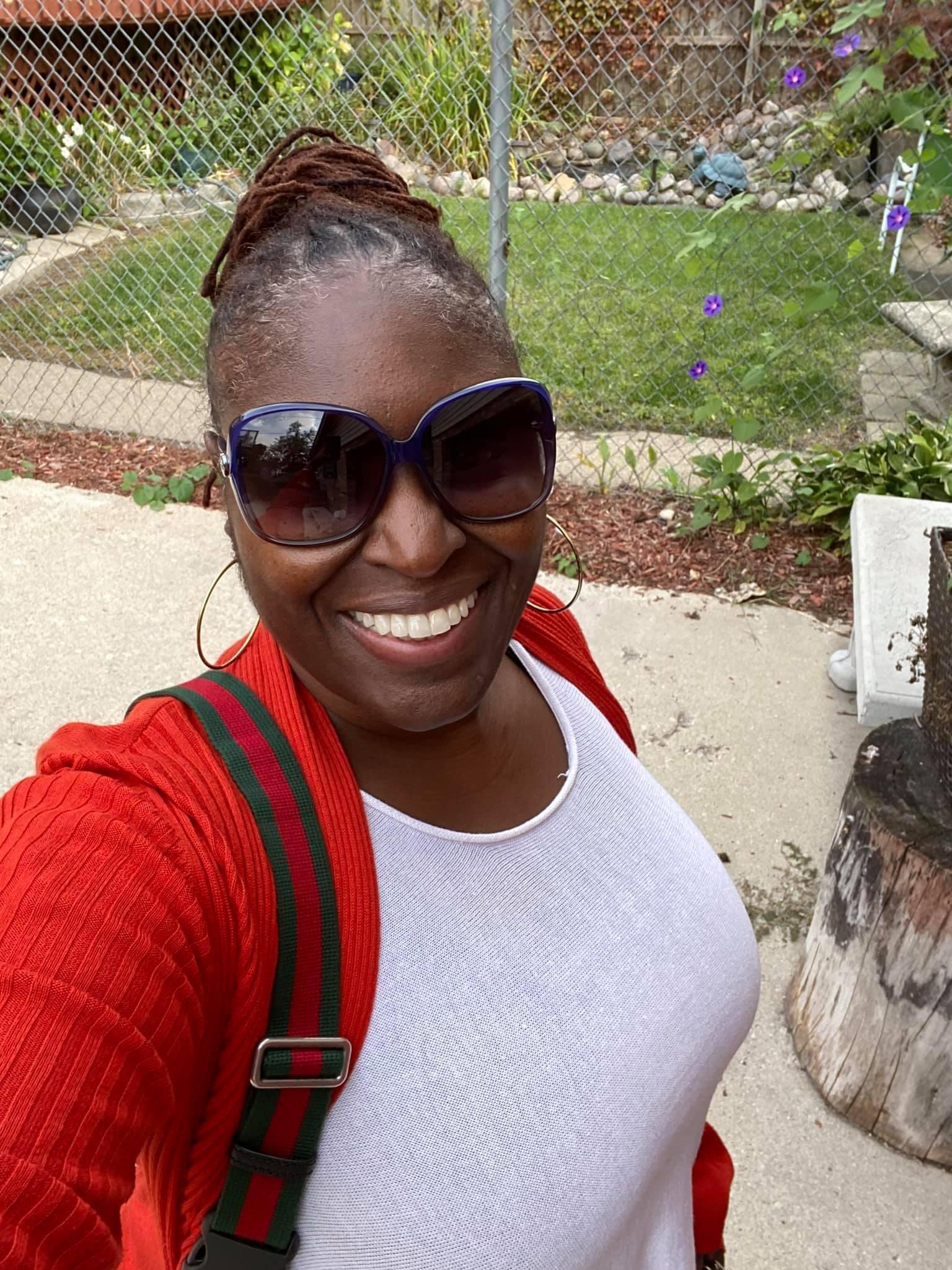 A woman wearing sunglasses and a red sweater