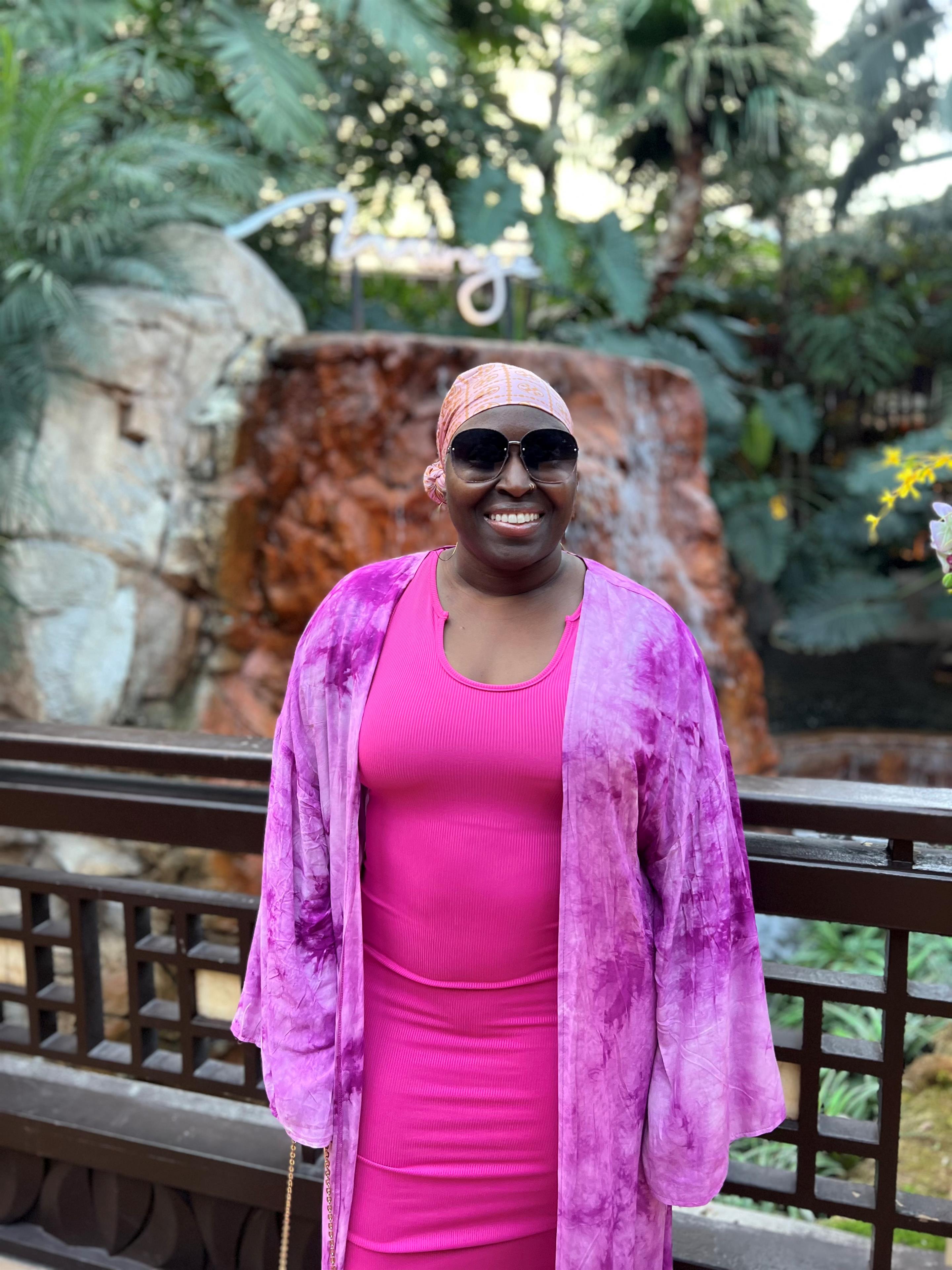 A woman in a pink dress and sunglasses