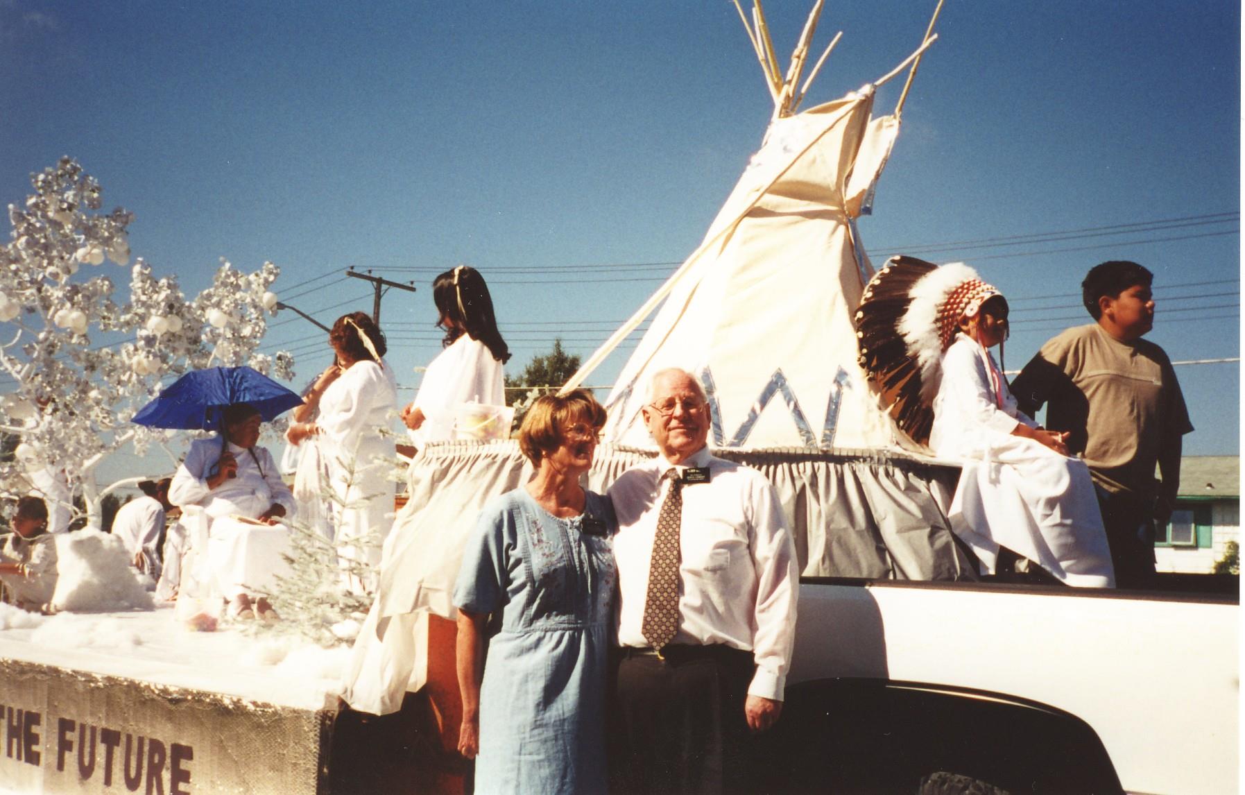 A man and woman standing next to a car