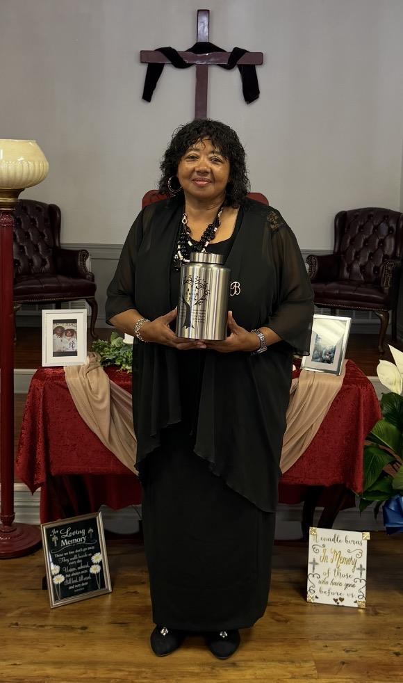 A woman holding a silver urn