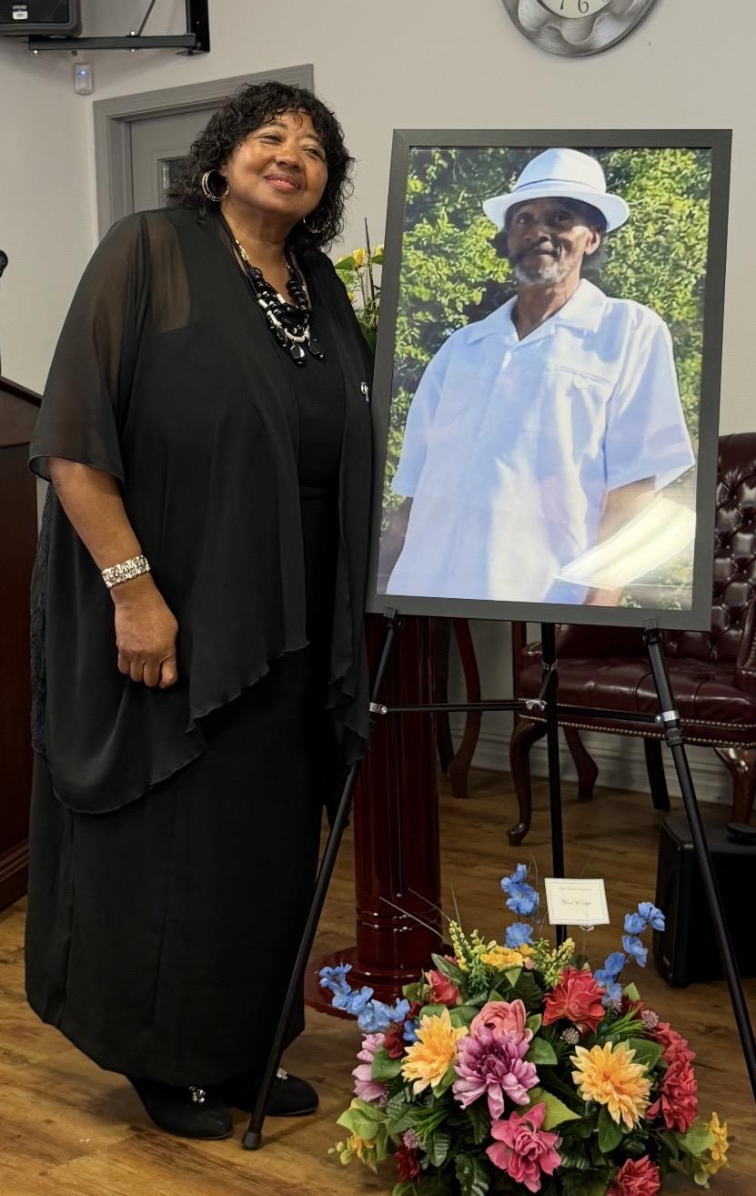 A woman standing next to a picture of a man