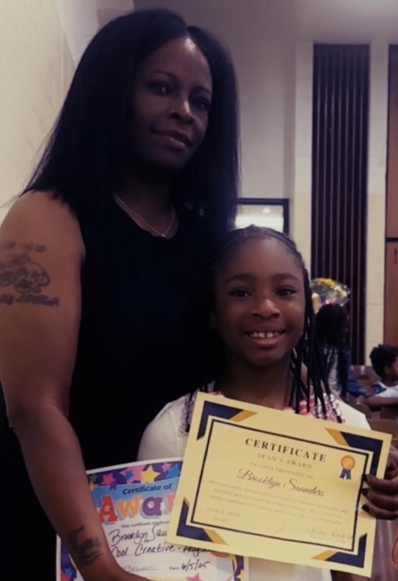A woman holding a certificate and smiling