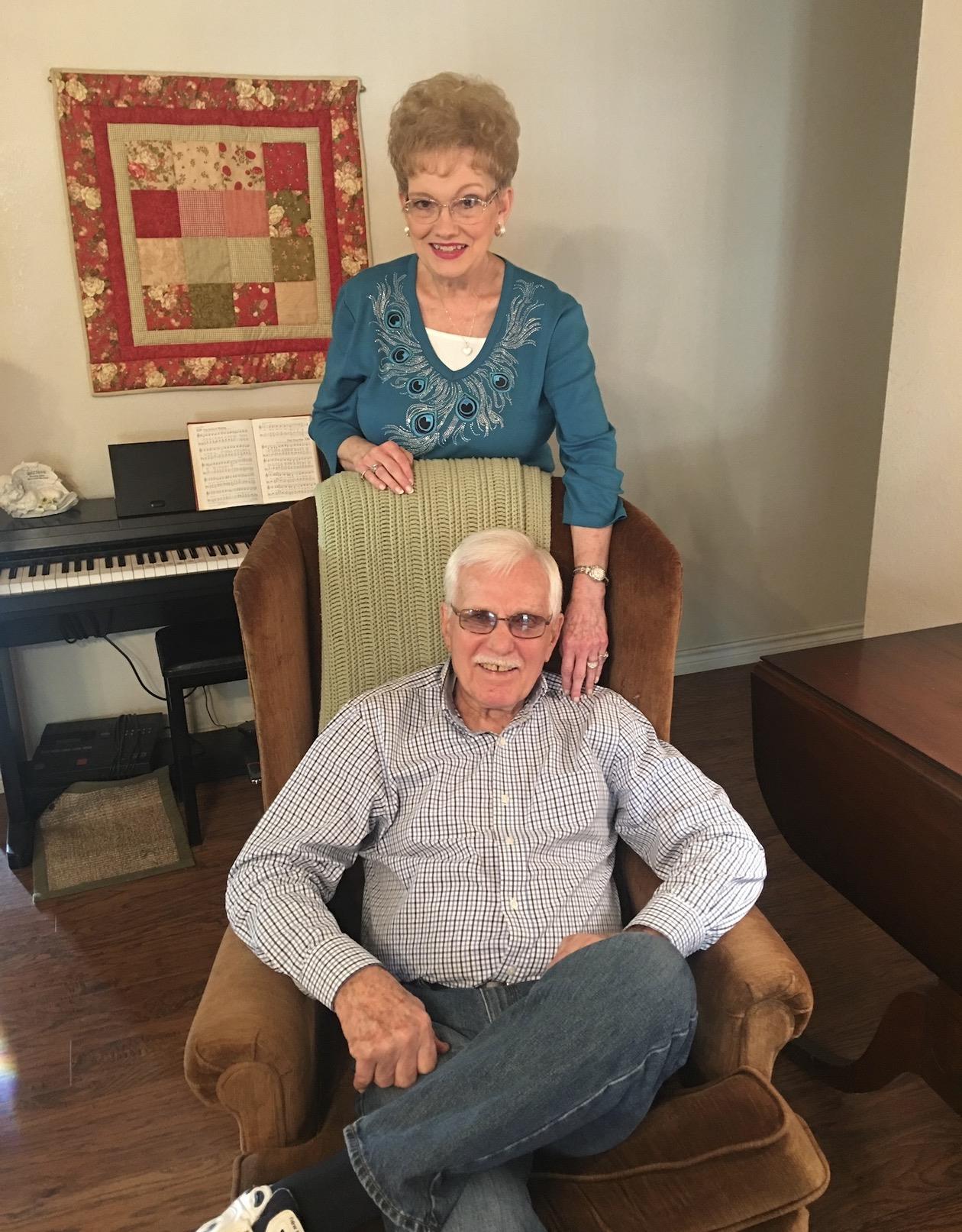 A man sitting in a chair with a woman standing behind him