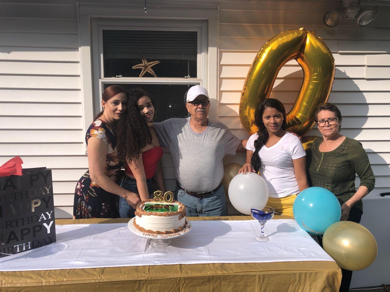 A group of people standing in front of a table with balloons