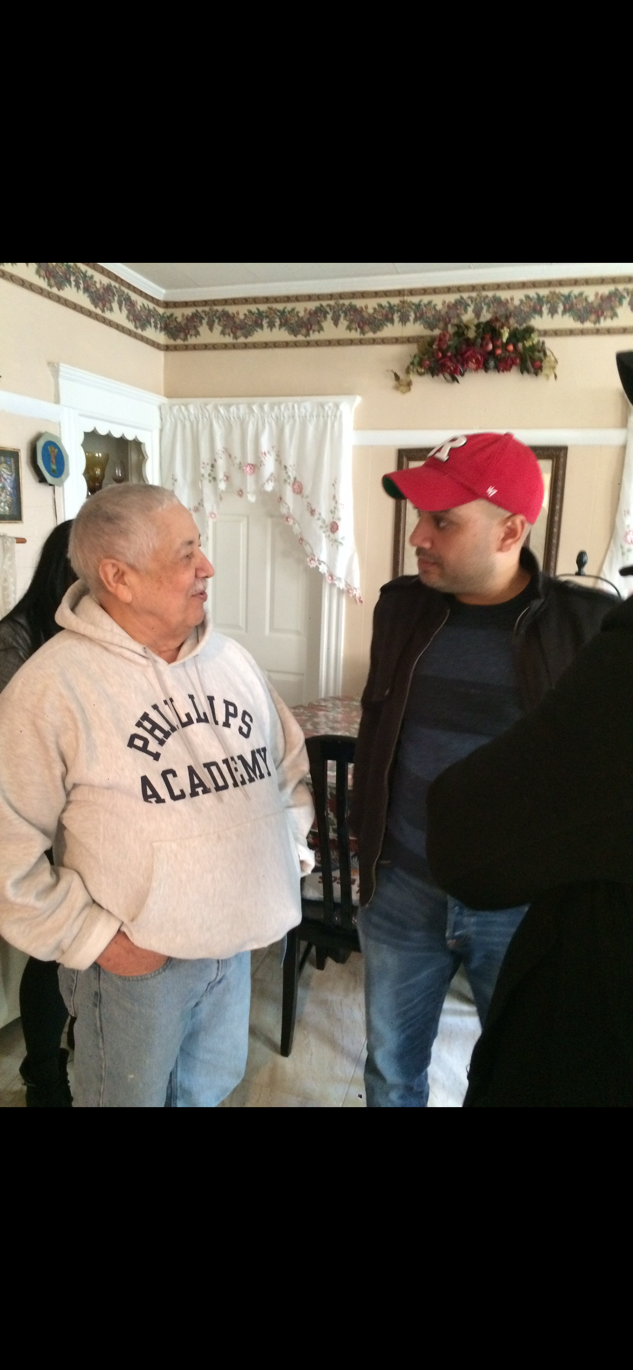 A man standing next to a man in a red hat