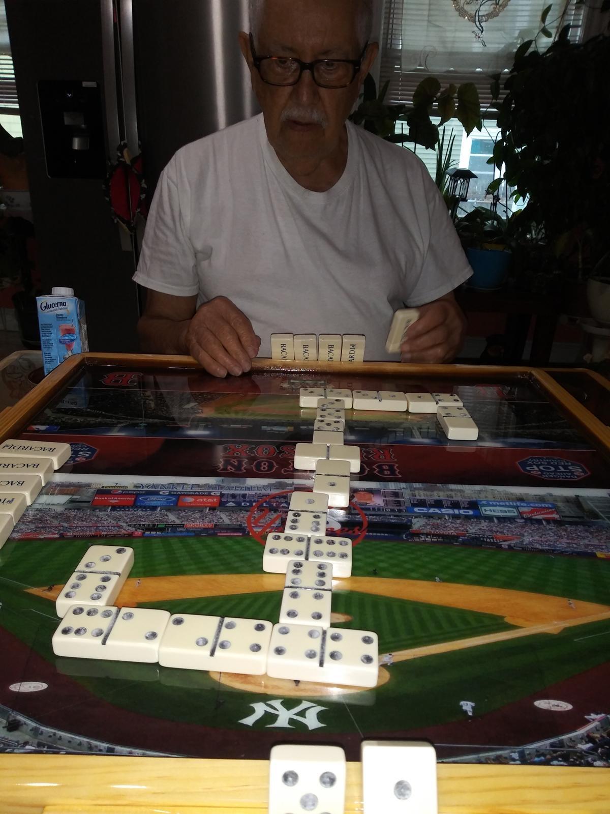 A man playing dominoes on a table