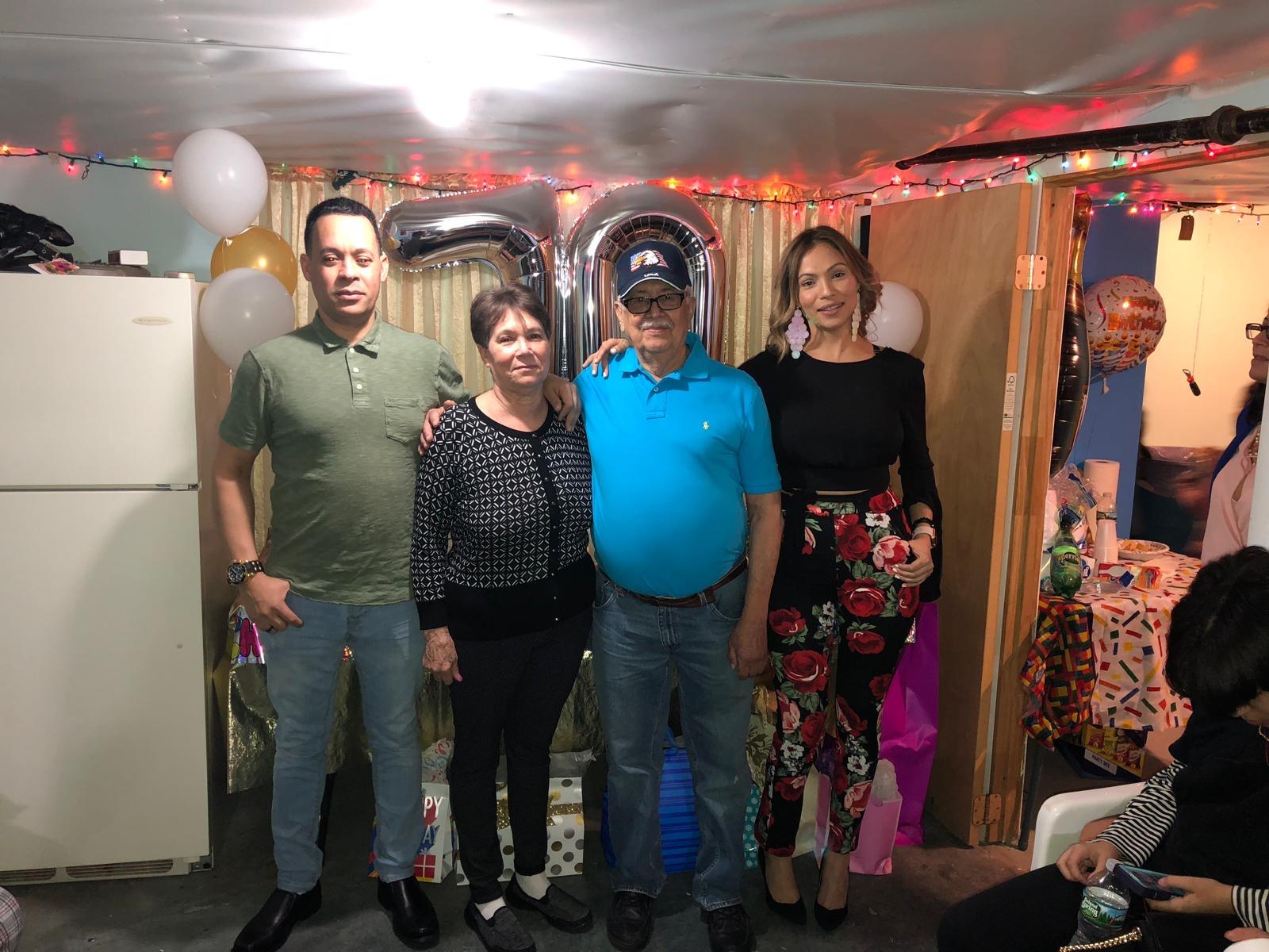 A group of people standing in a room with balloons and lights