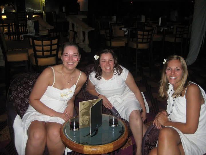 A group of women in white dresses sitting at a table