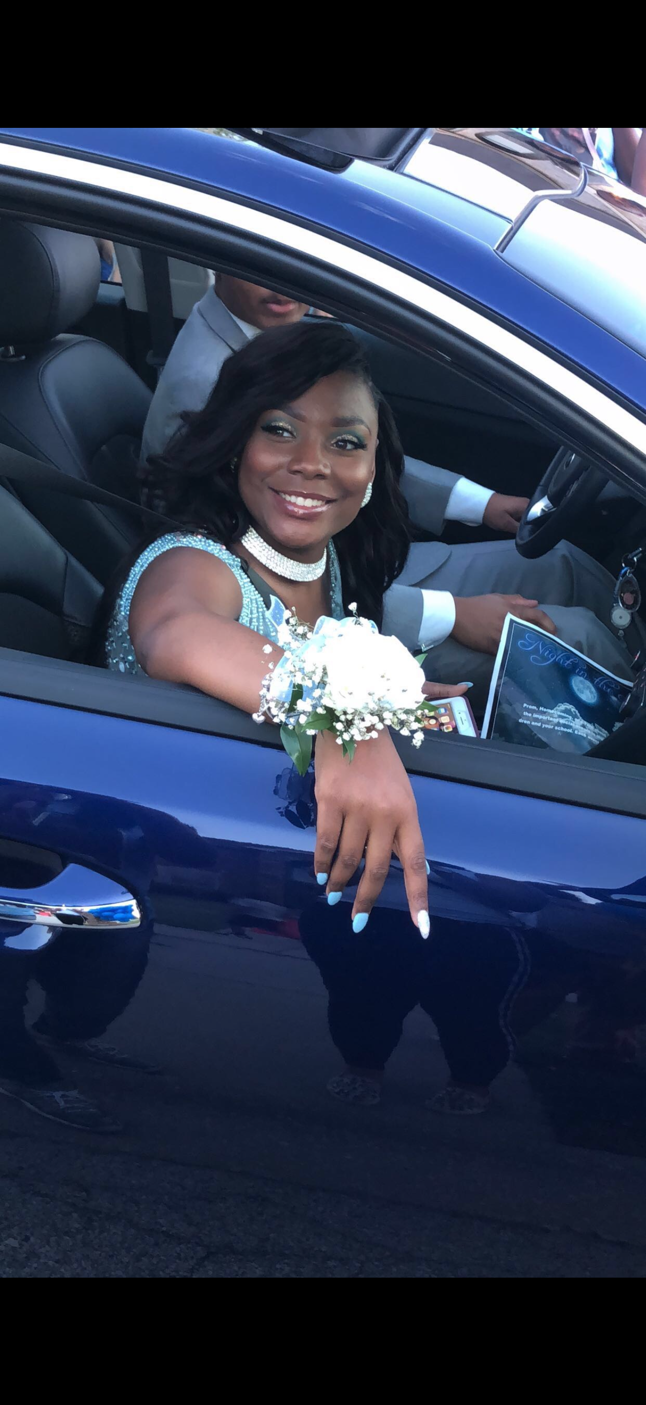 A woman in a blue dress sitting in a car