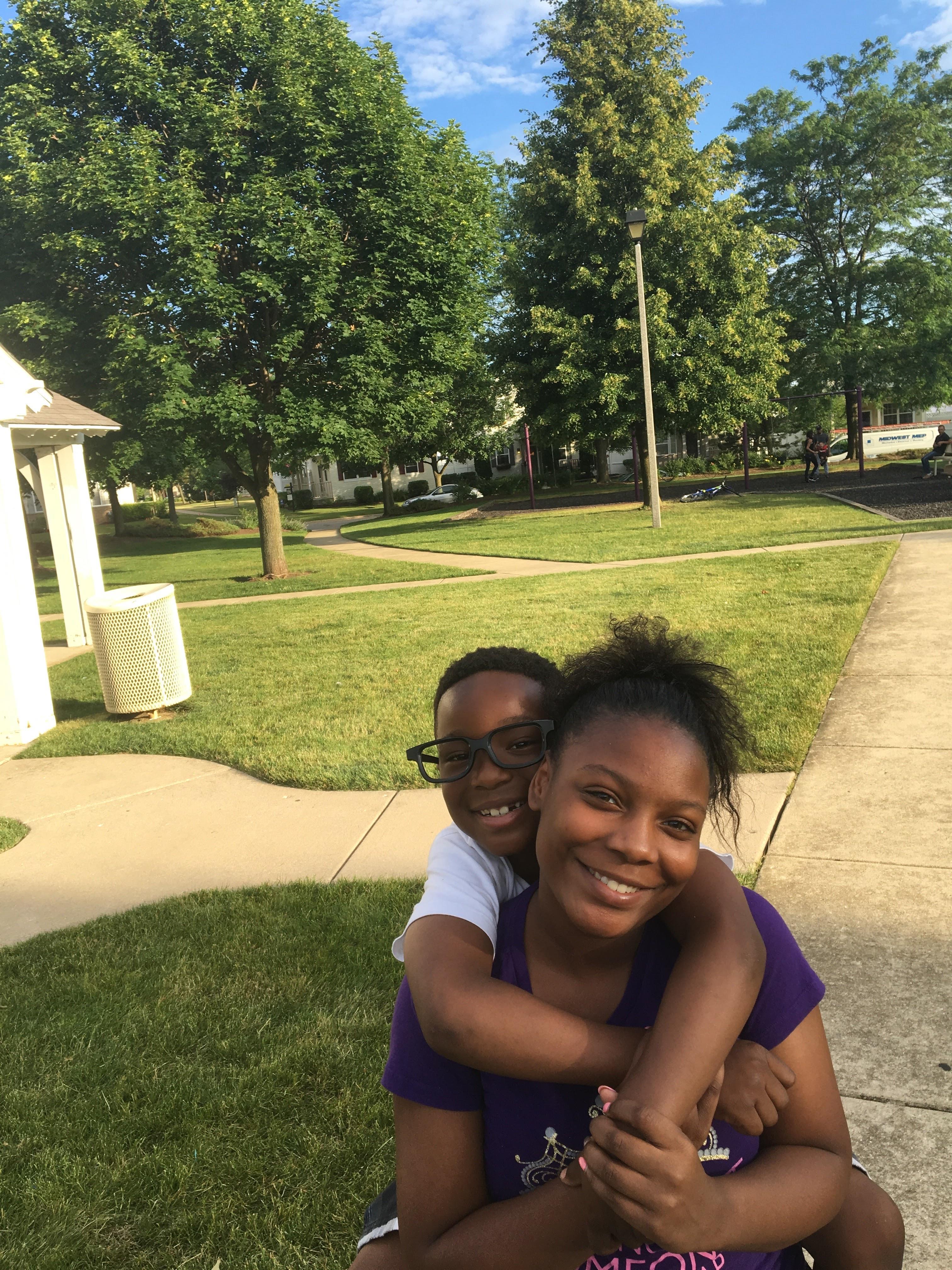 A woman hugging a boy in a park