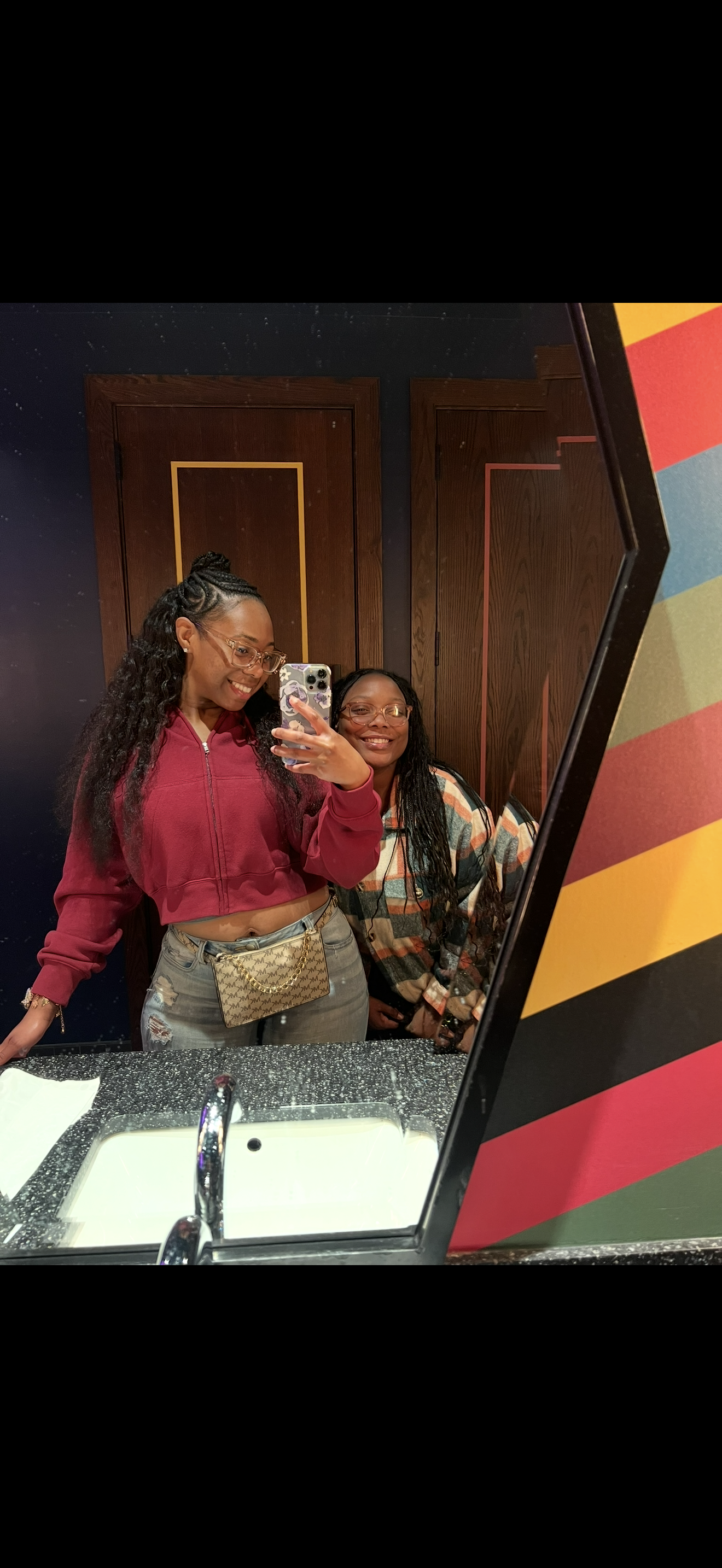 Two women taking a selfie in a mirror