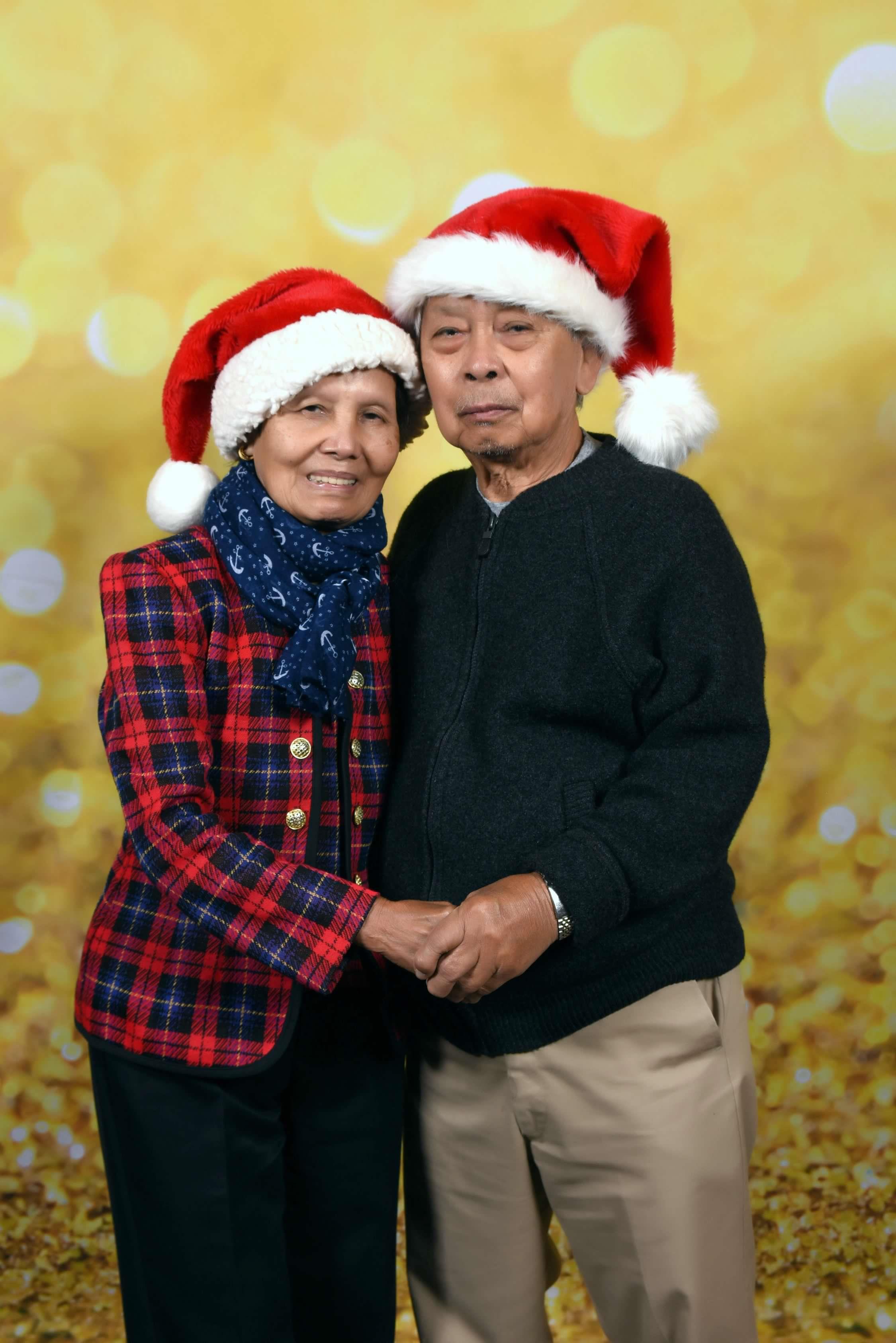 A man and woman wearing santa hats