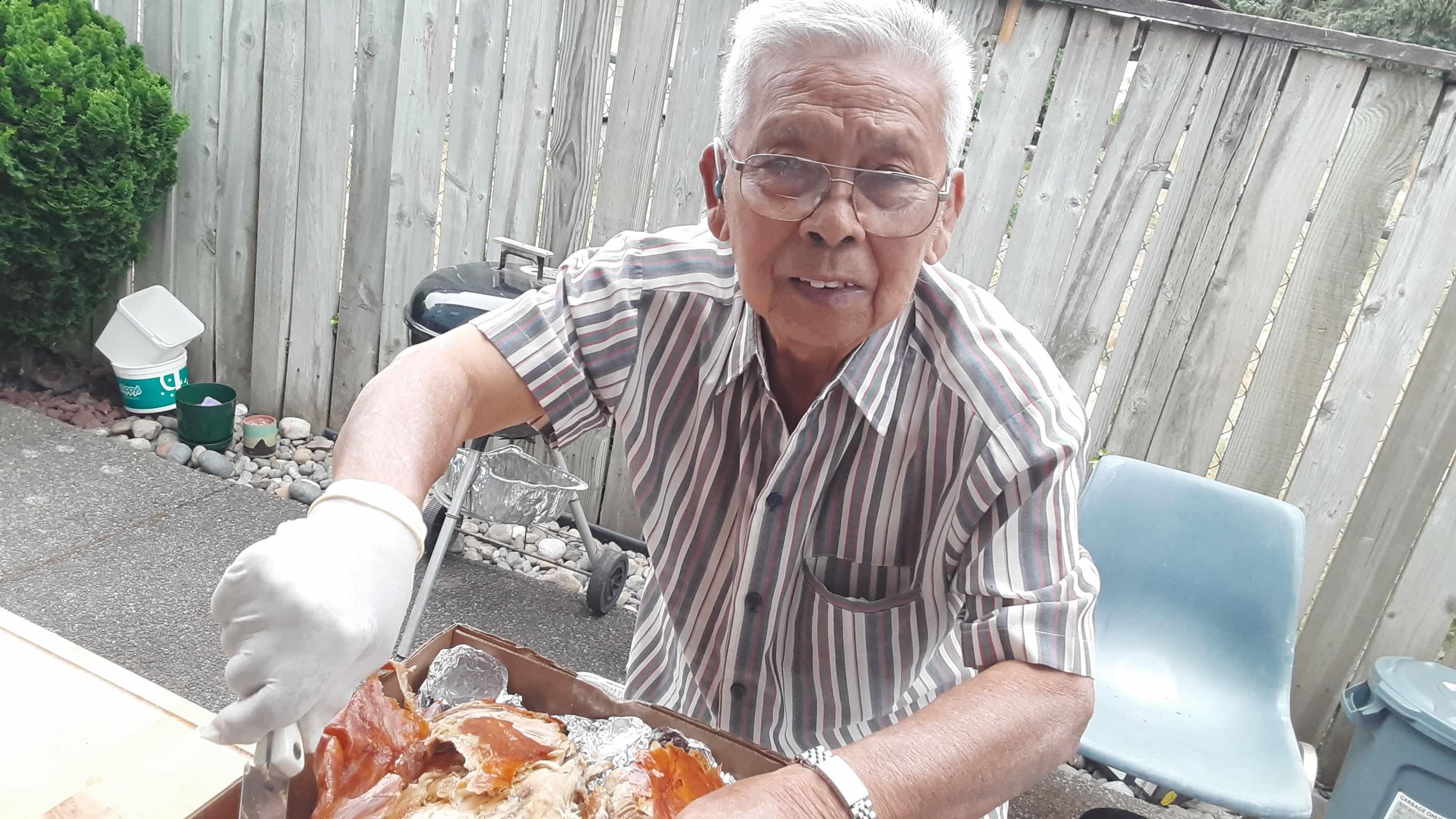 An old man holding a tray of food