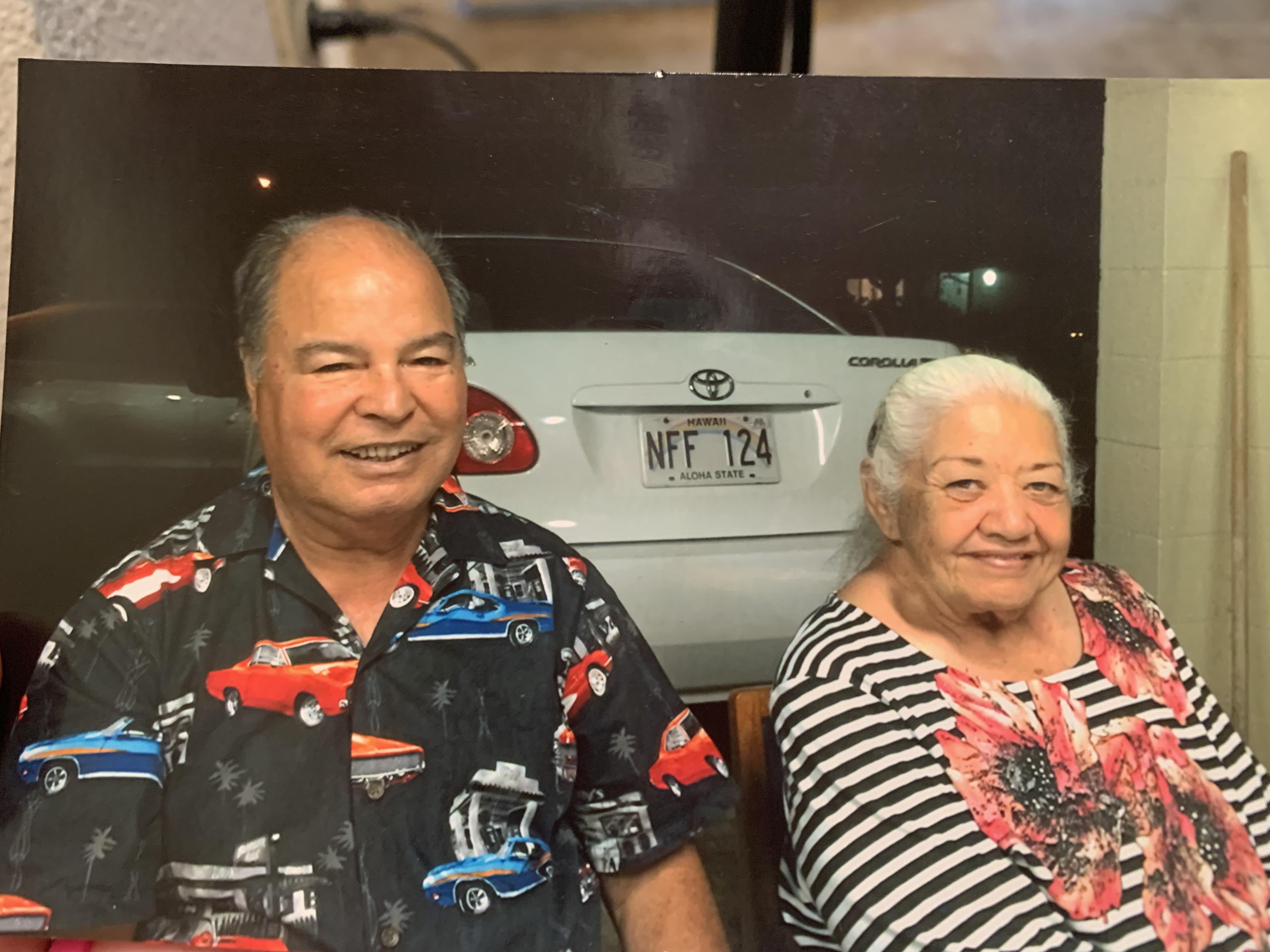 A man and woman sitting in front of a car