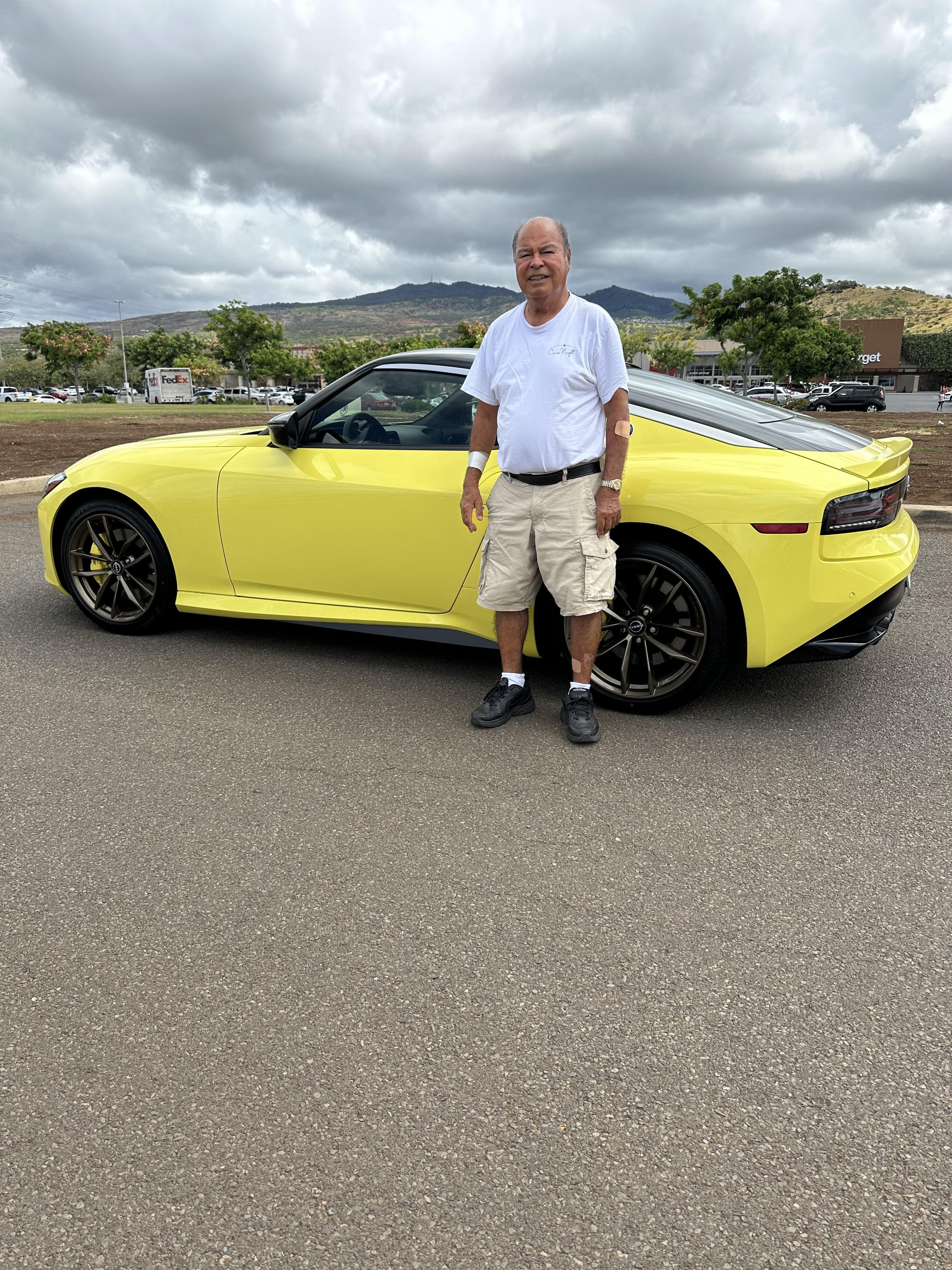 A man standing next to a yellow sports car
