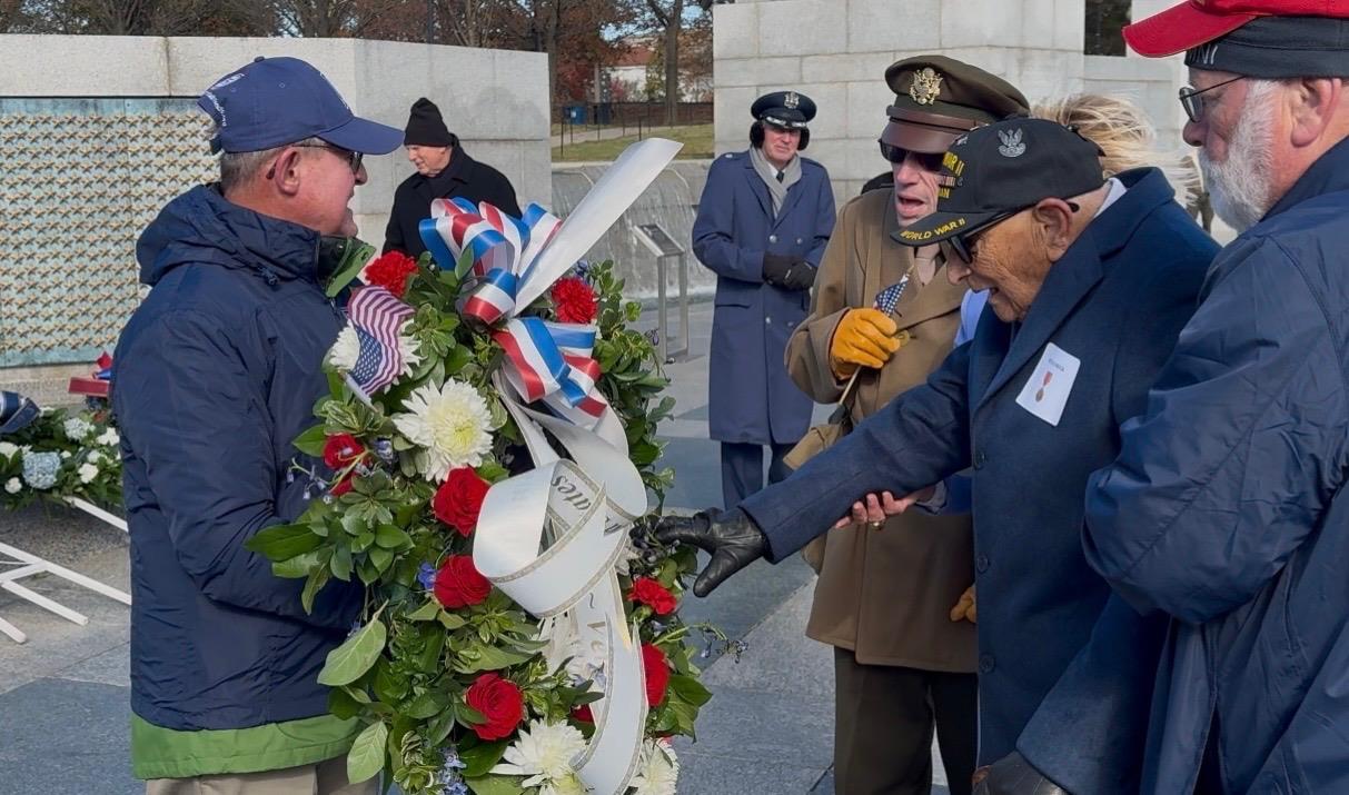A man in uniform holding a wreath