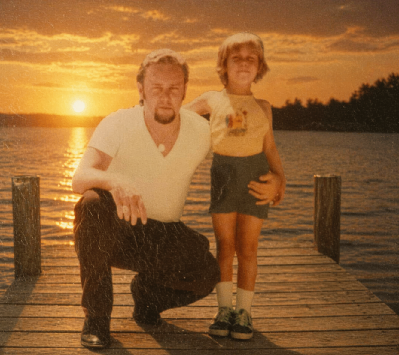 A man and child posing for a picture on a dock
