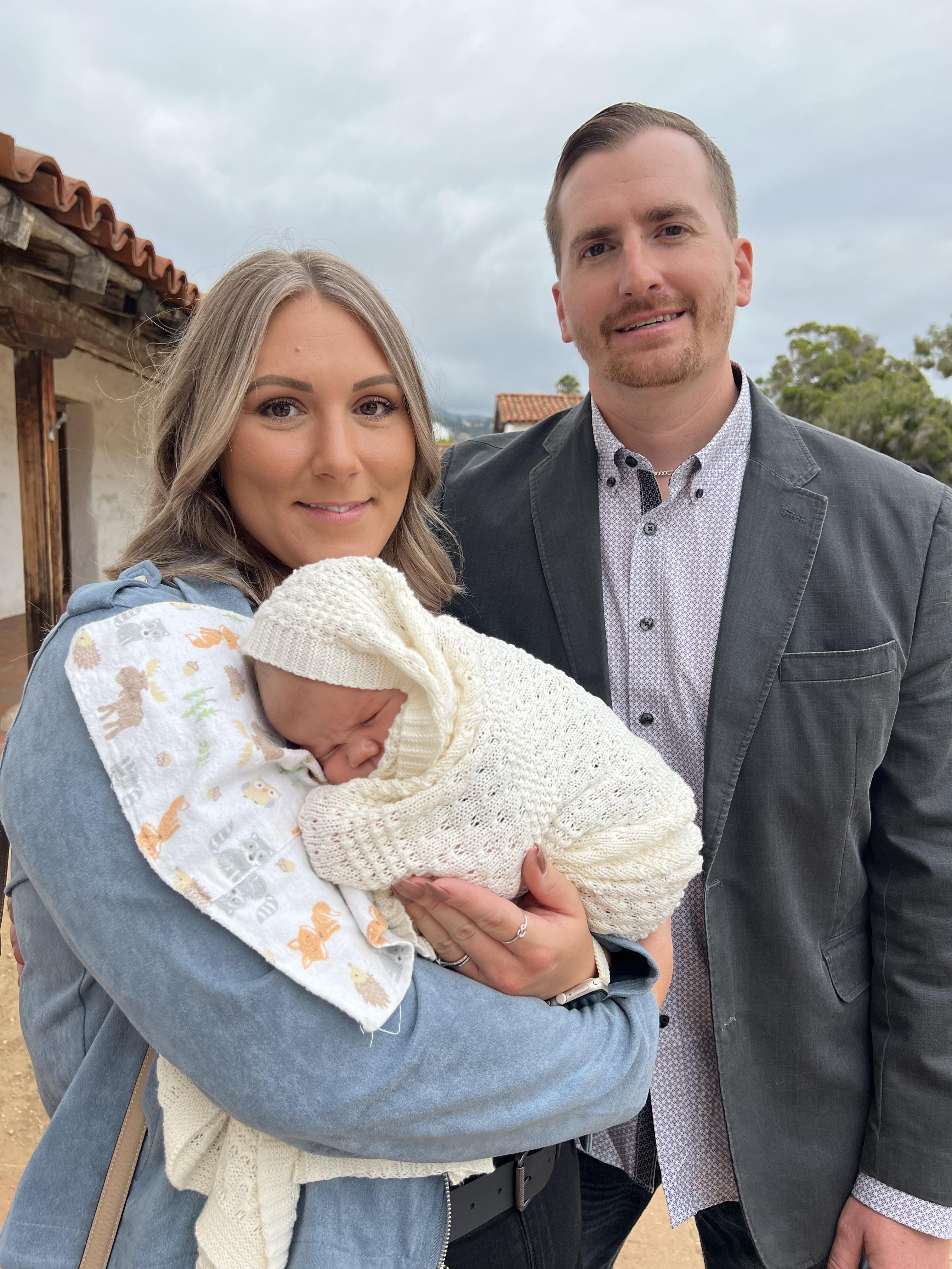 A man and woman holding a baby