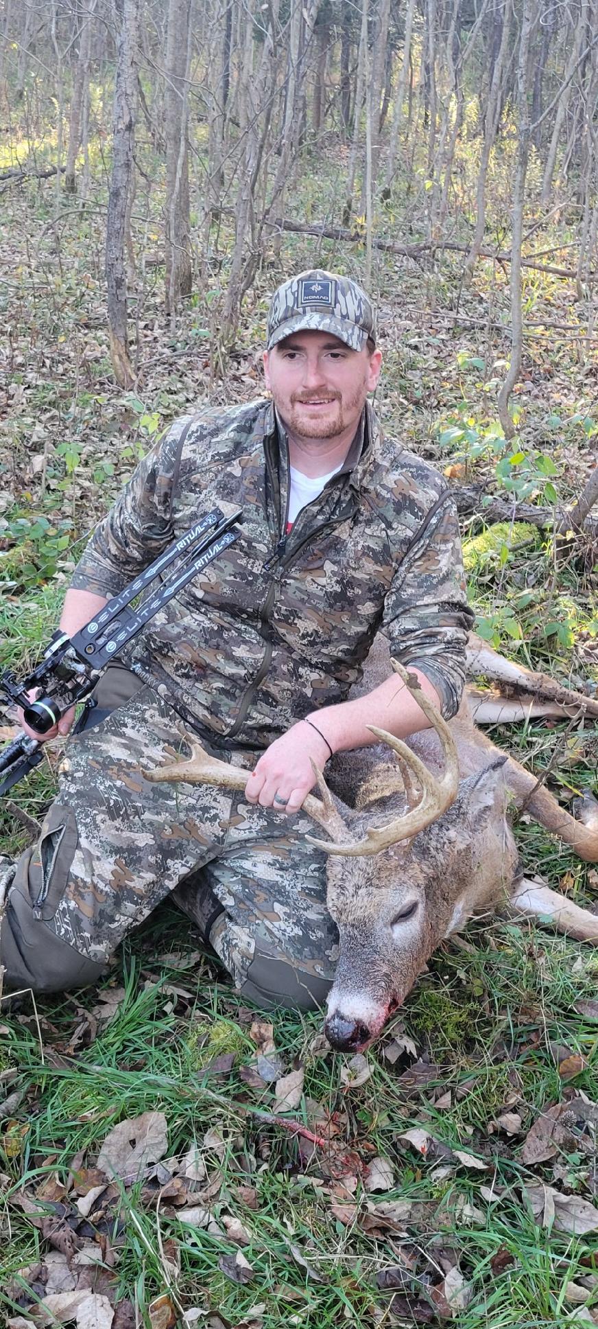 A man holding a gun and a deer