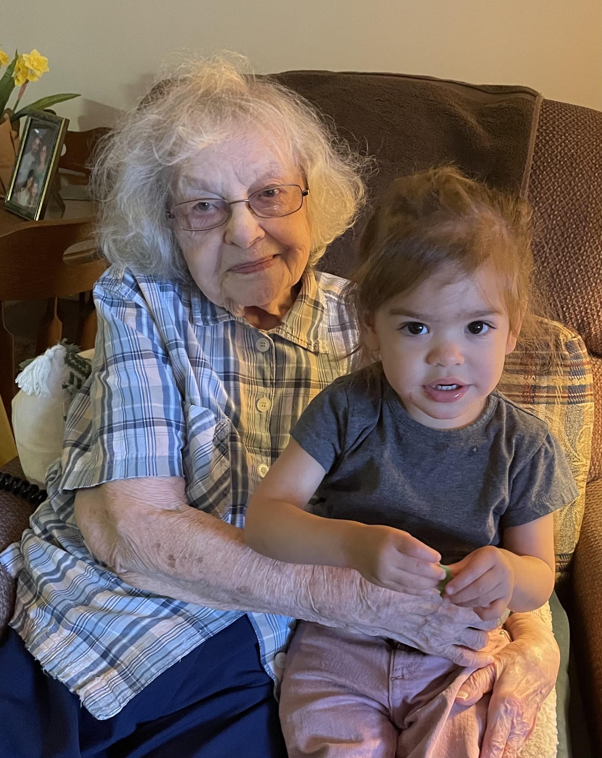 An old woman and a young girl sitting on a couch