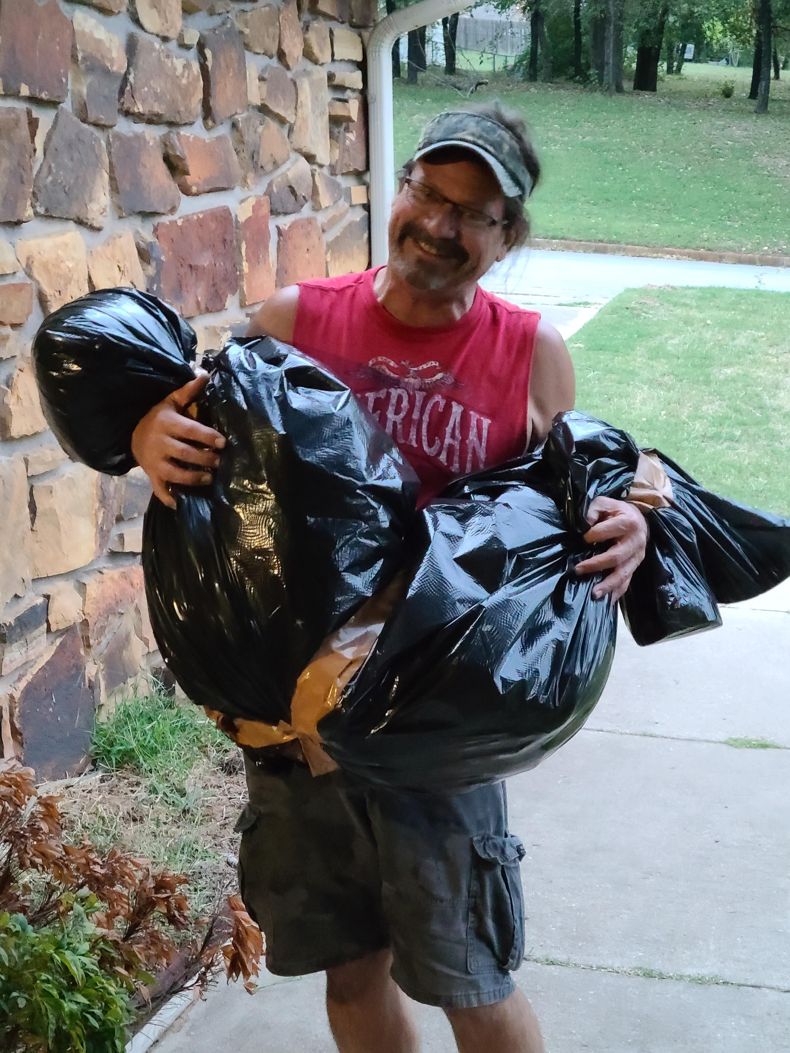 A man holding a bag of garbage