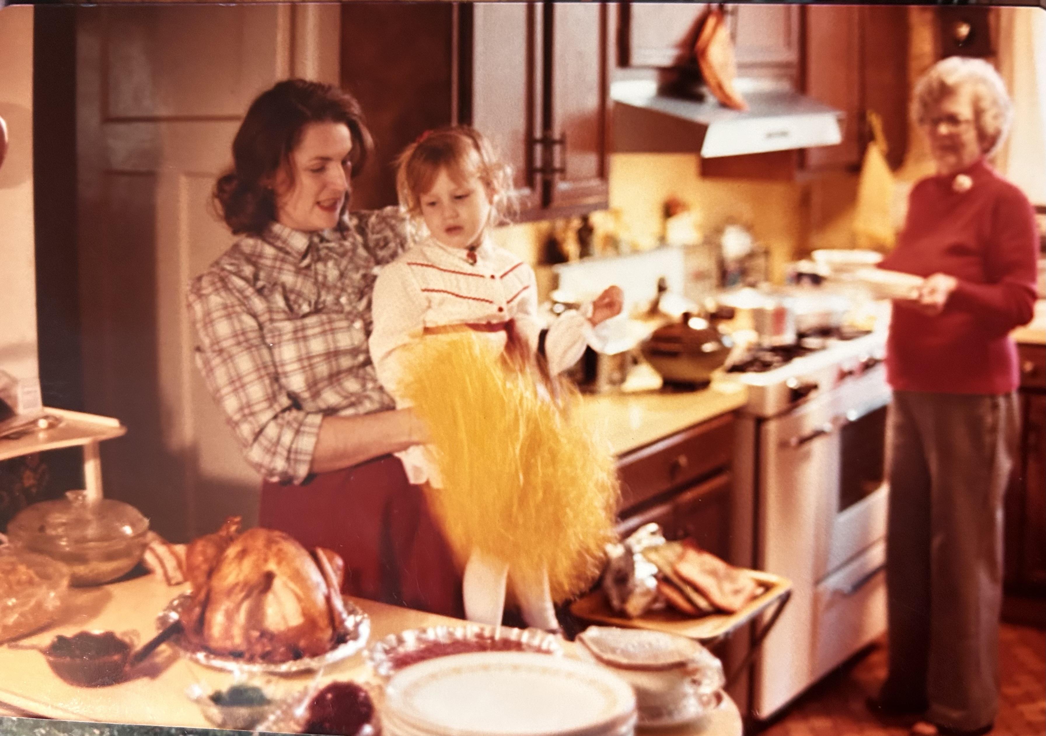 A woman holding a child in a kitchen