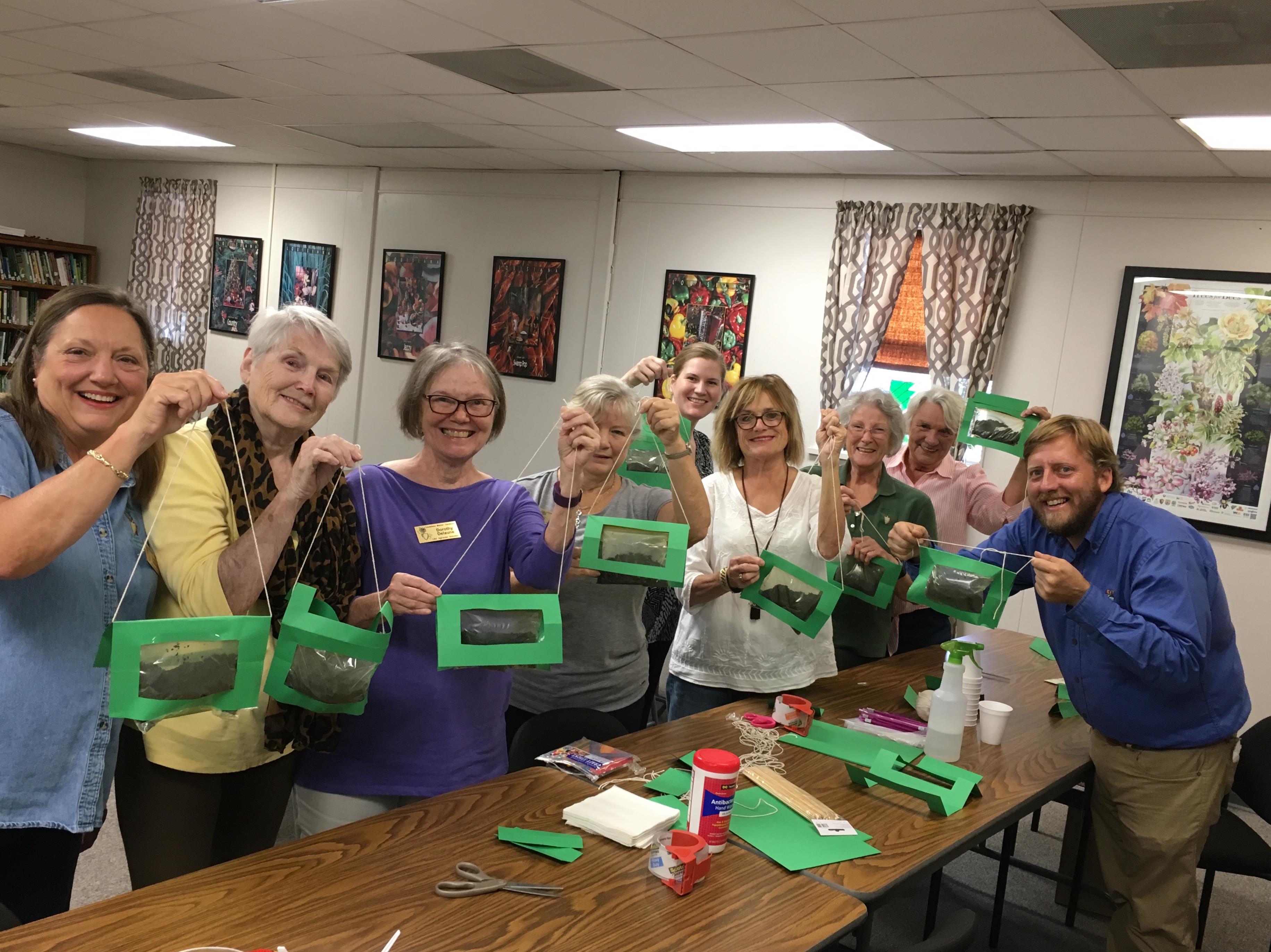 A group of people holding green objects