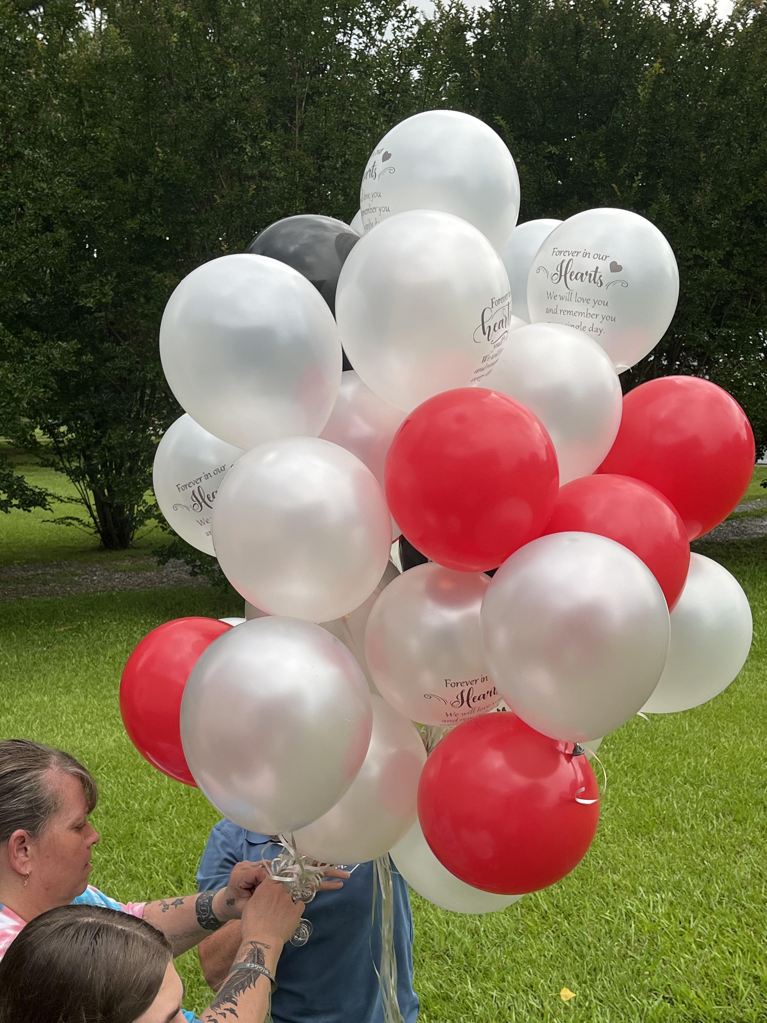 A woman holding a bunch of balloons