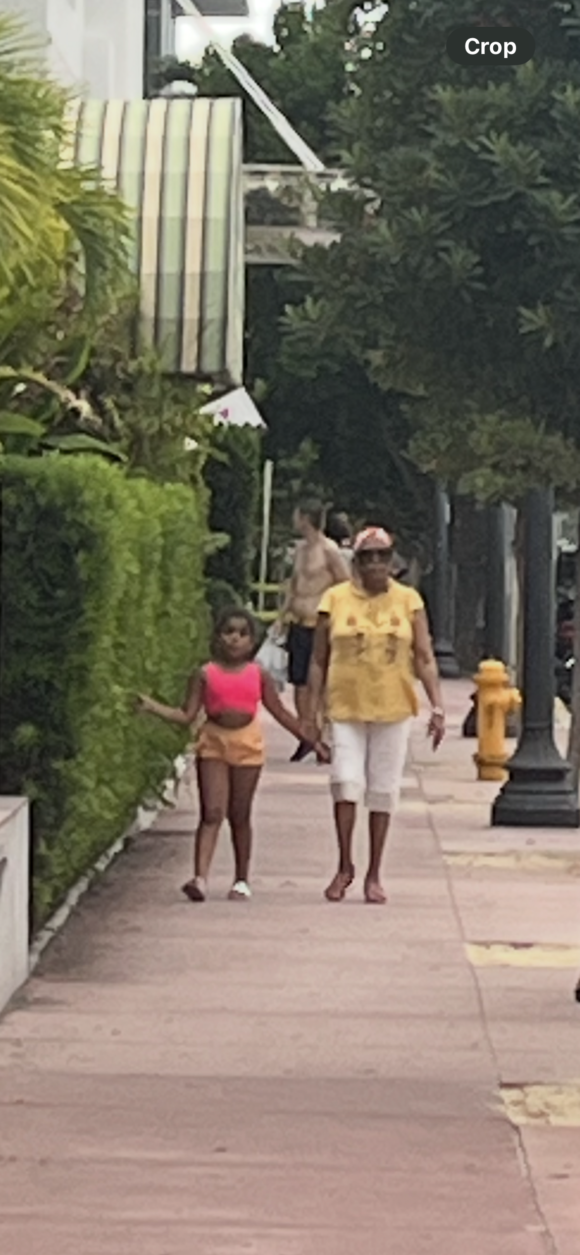 A woman and a girl walking on a sidewalk