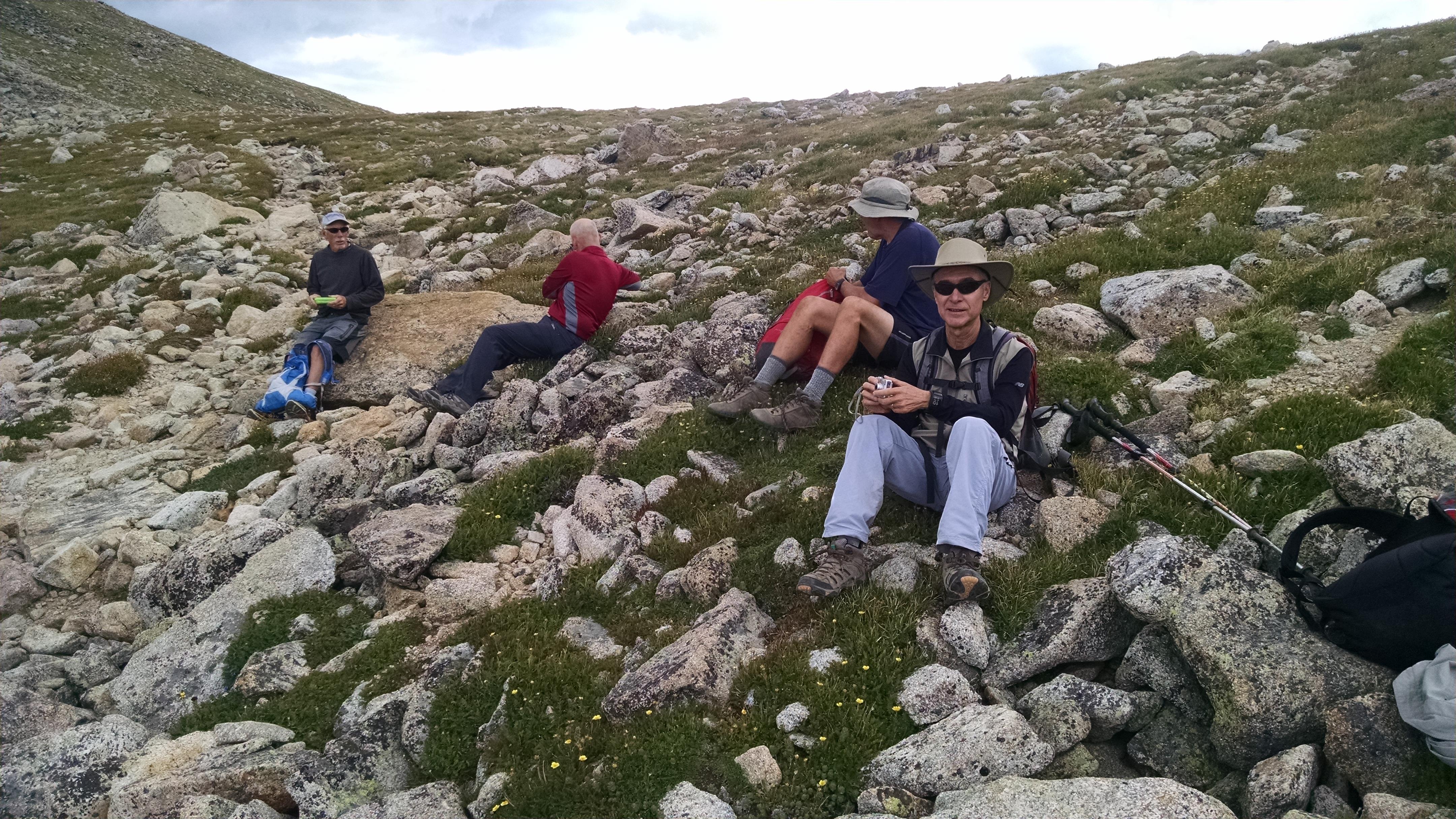 A group of people sitting on a rocky hill