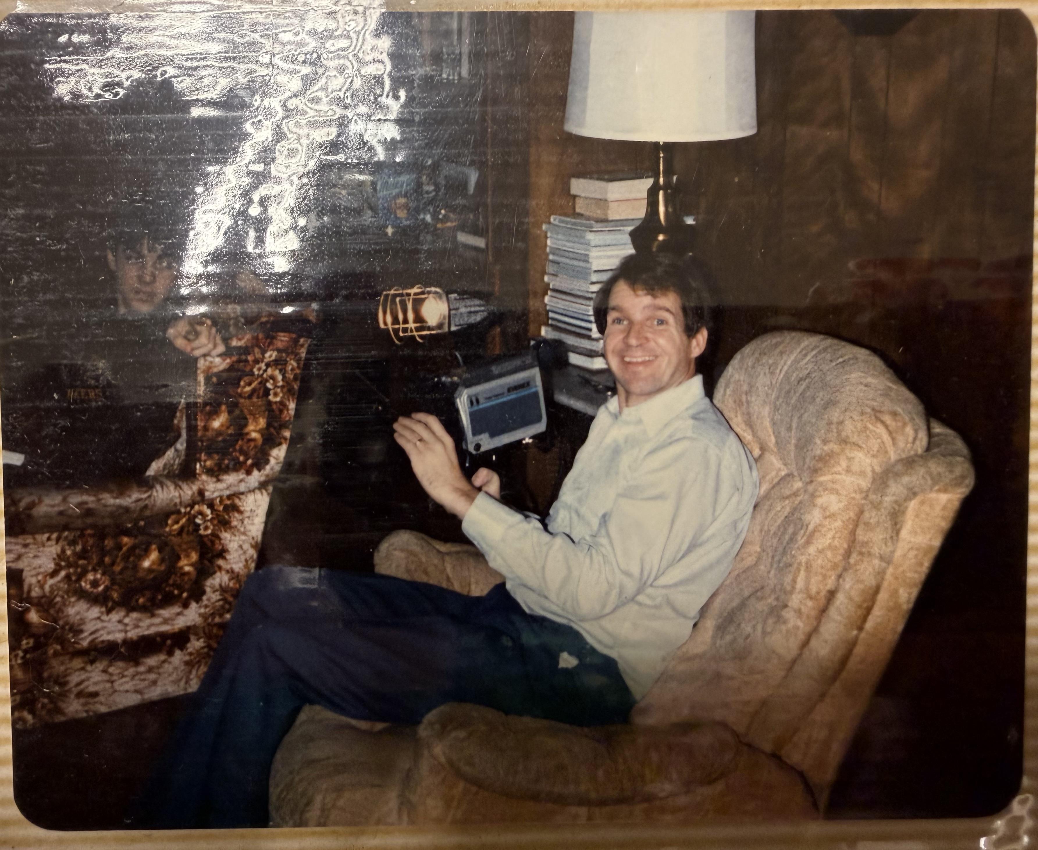 A man sitting in a chair holding a device