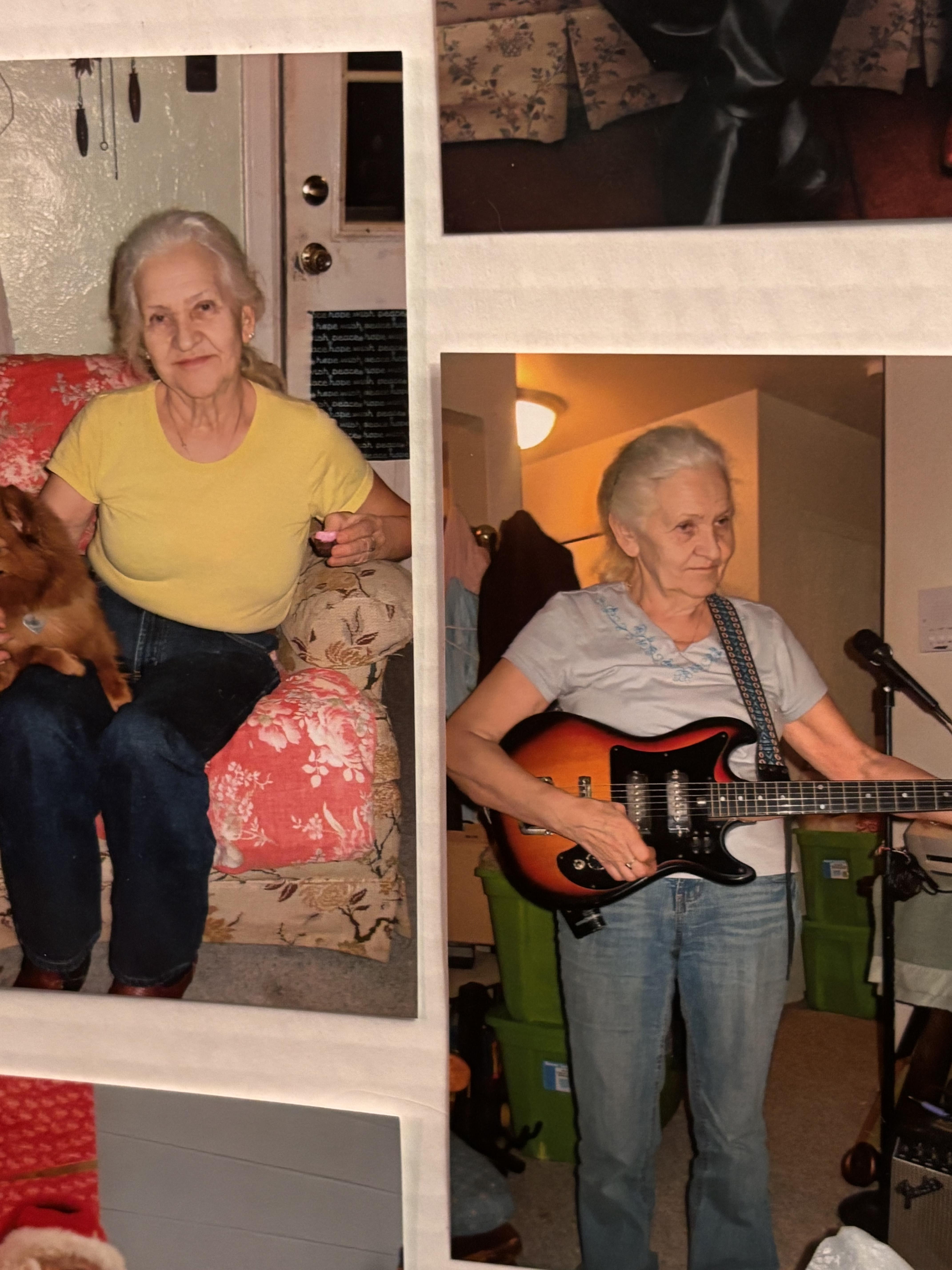 A woman holding a guitar and a dog